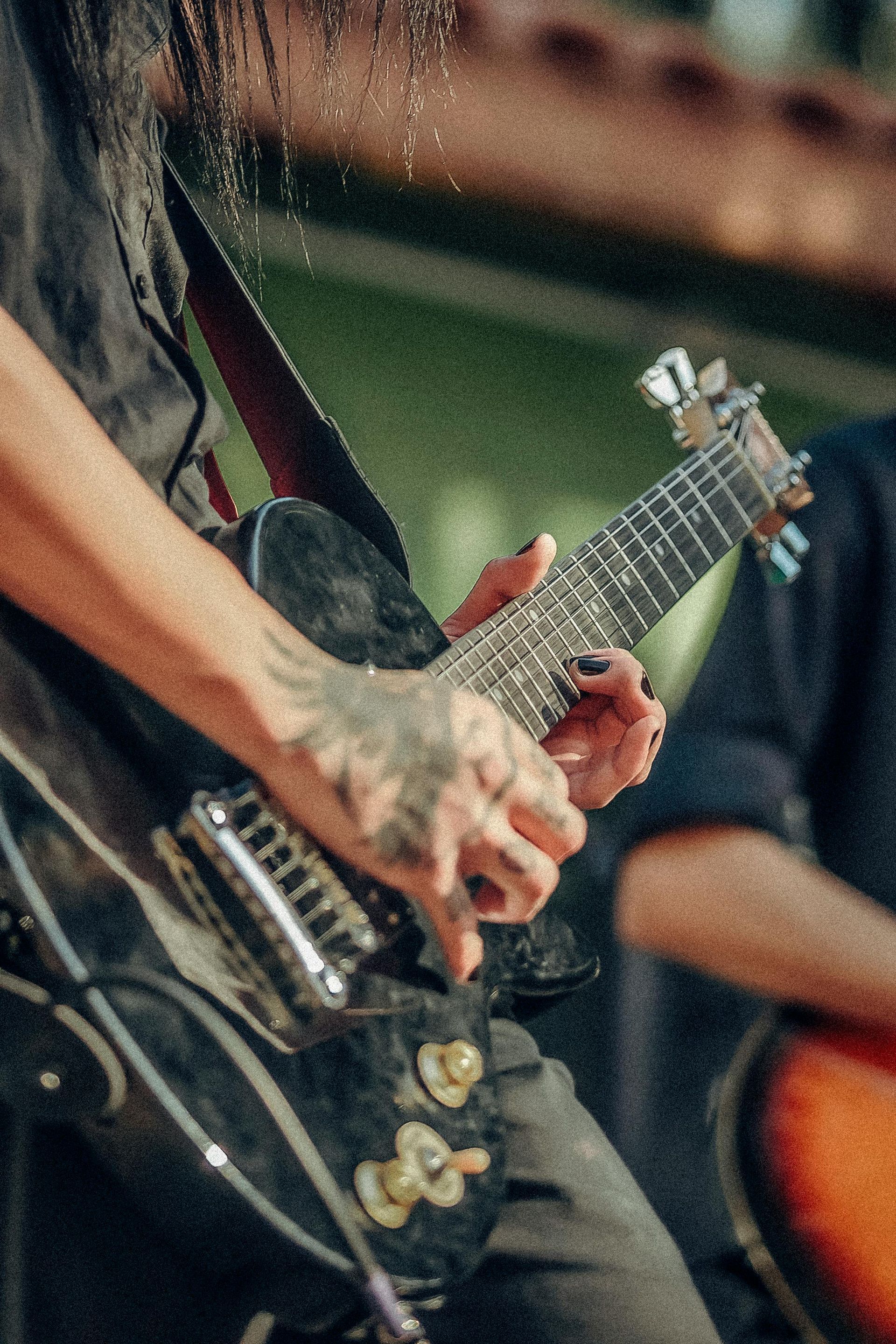 Um homem de cabelo comprido está tocando uma guitarra elétrica