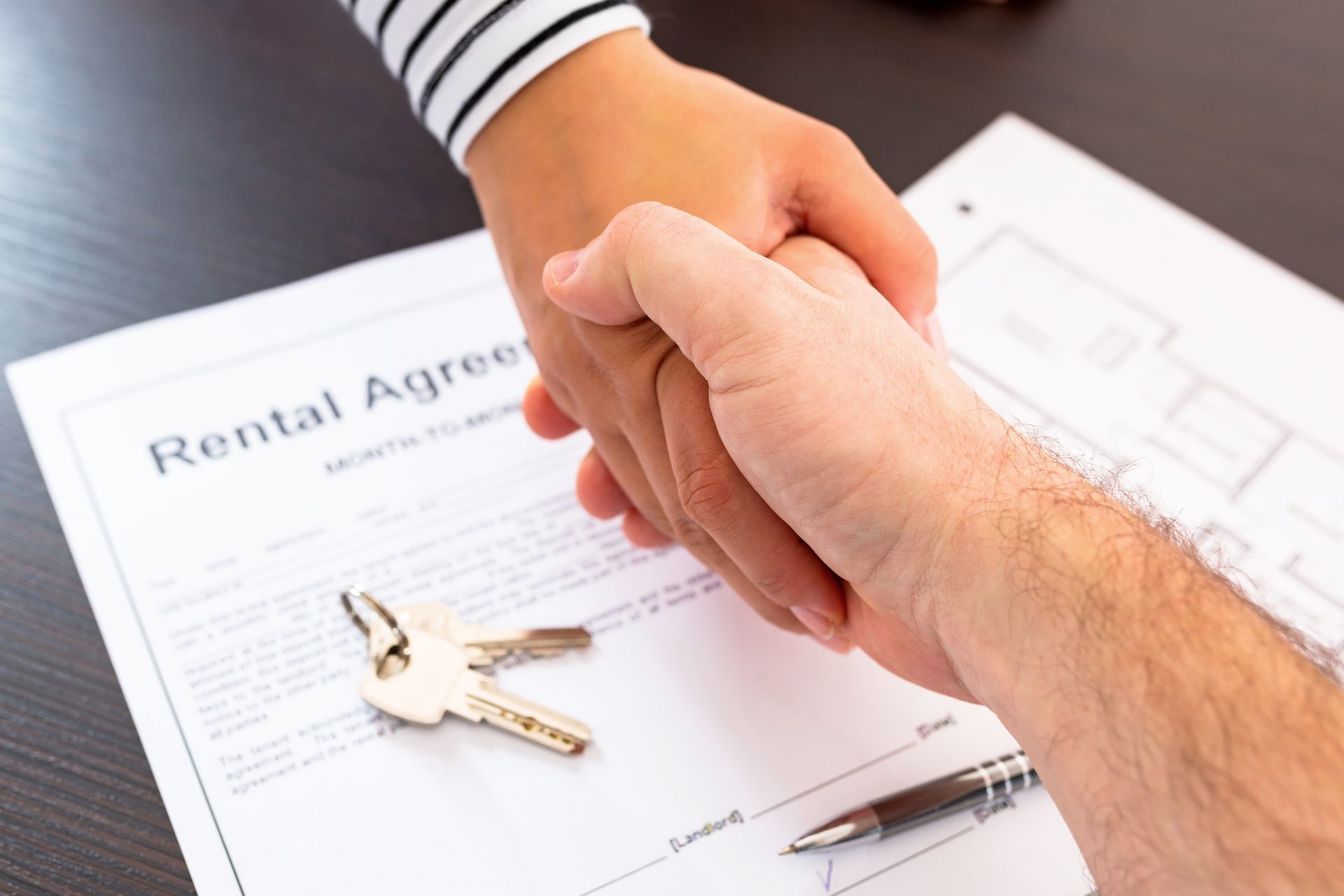 A realtor from a real estate rental agency and a client, handshaking after signing an agreement. A realtor from a real estate rental agency and a client, handshaking after signing an agreement.