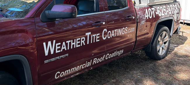 A red WeatherTite truck is parked on the side of the road.