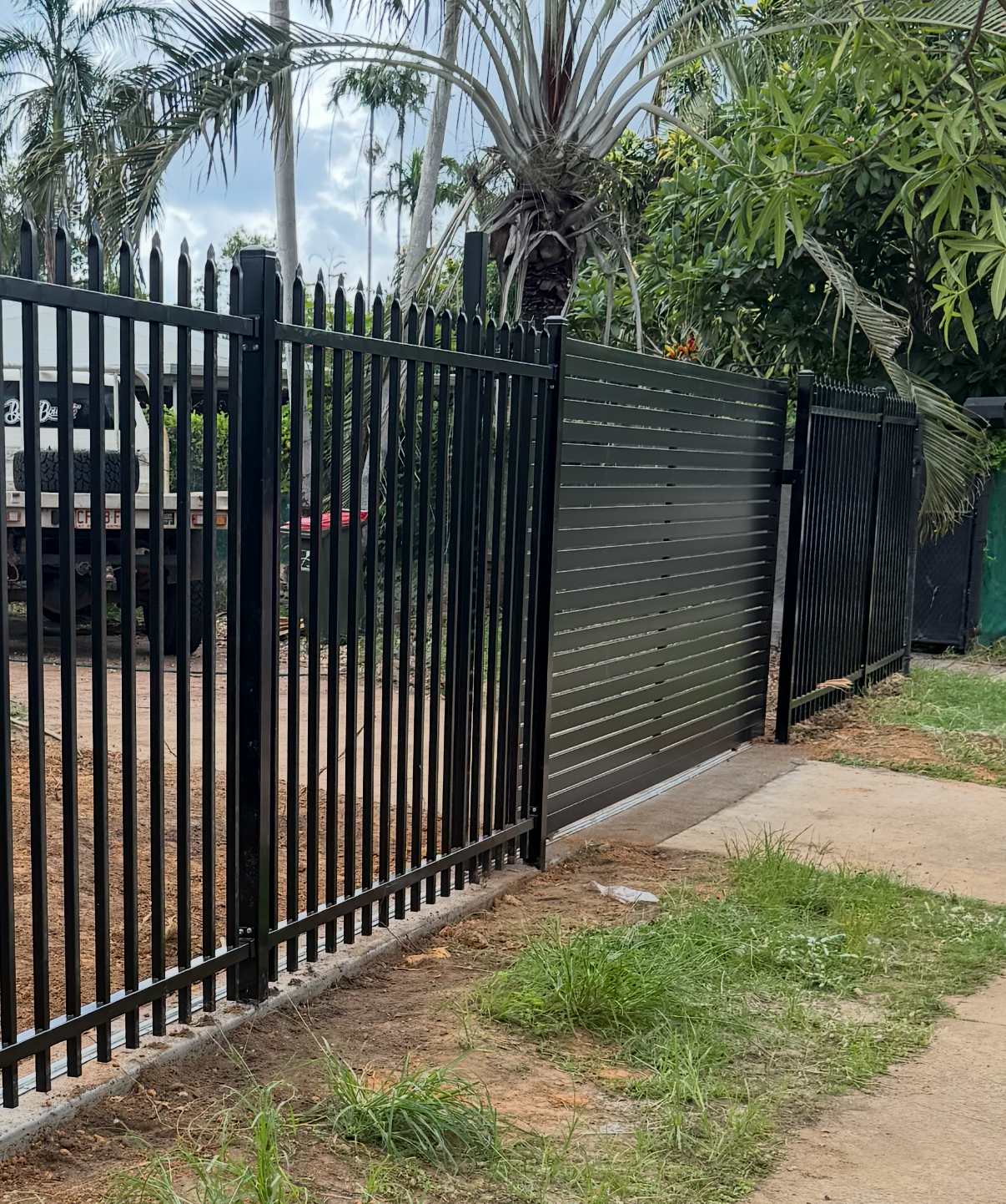 Black metal fence and gate with concrete edging, front yard. — True North Fencing in Noonamah, NT