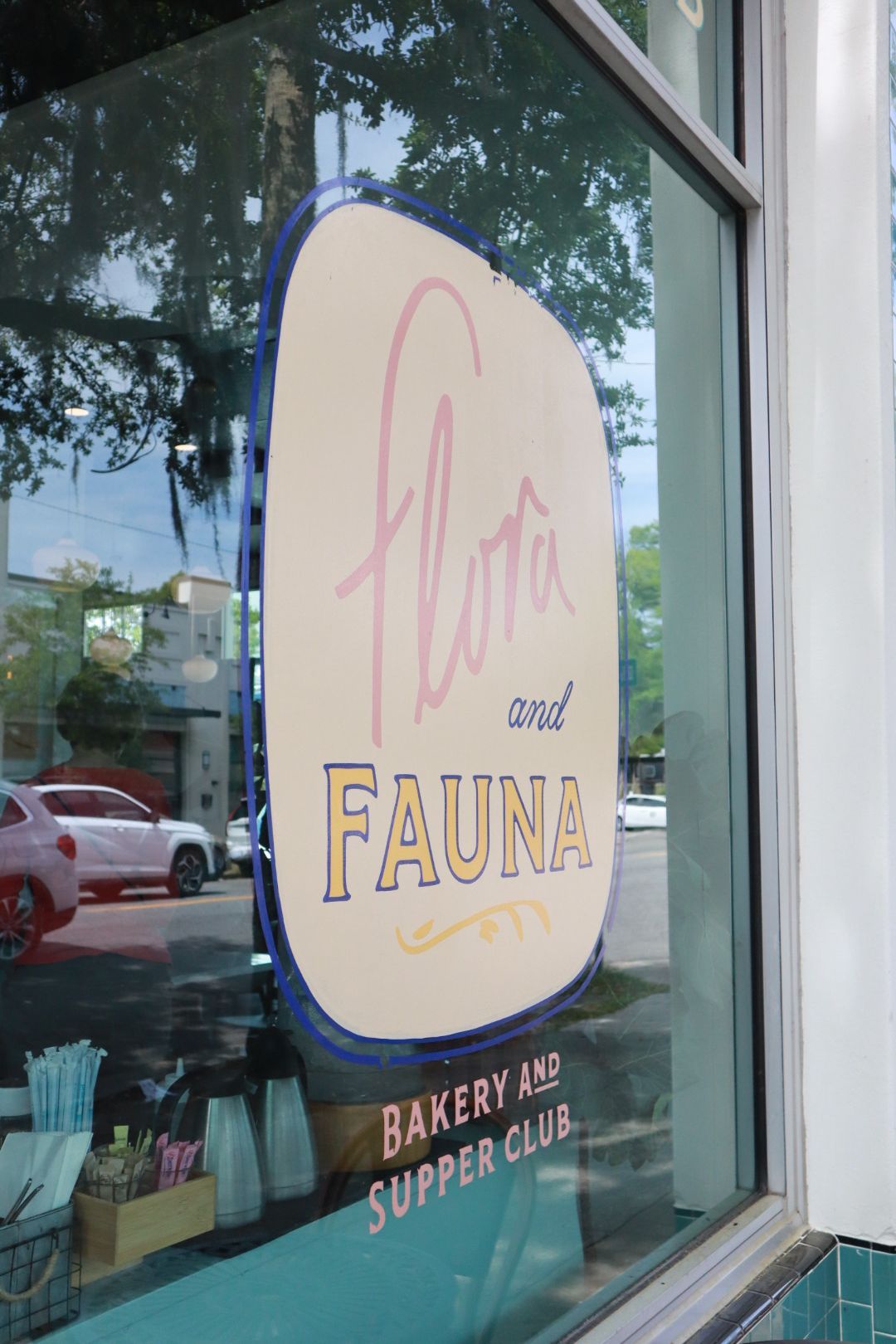 Storefront window sign for Flora and Fauna Bakery and Supper Club.