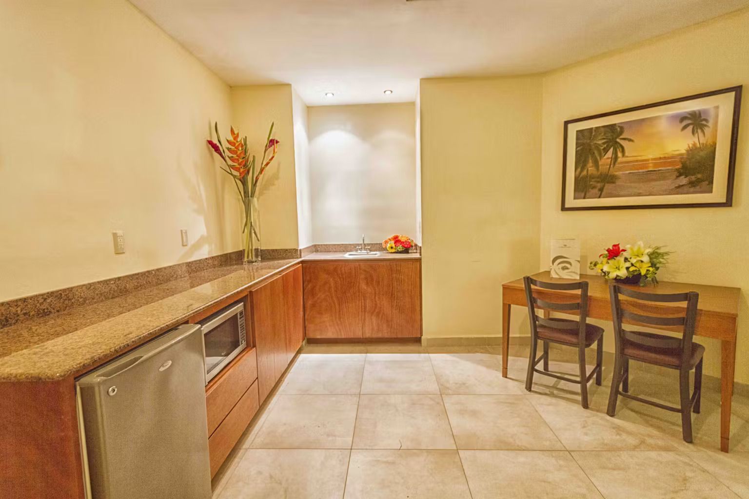 A kitchen with a table and chairs and a picture on the wall.