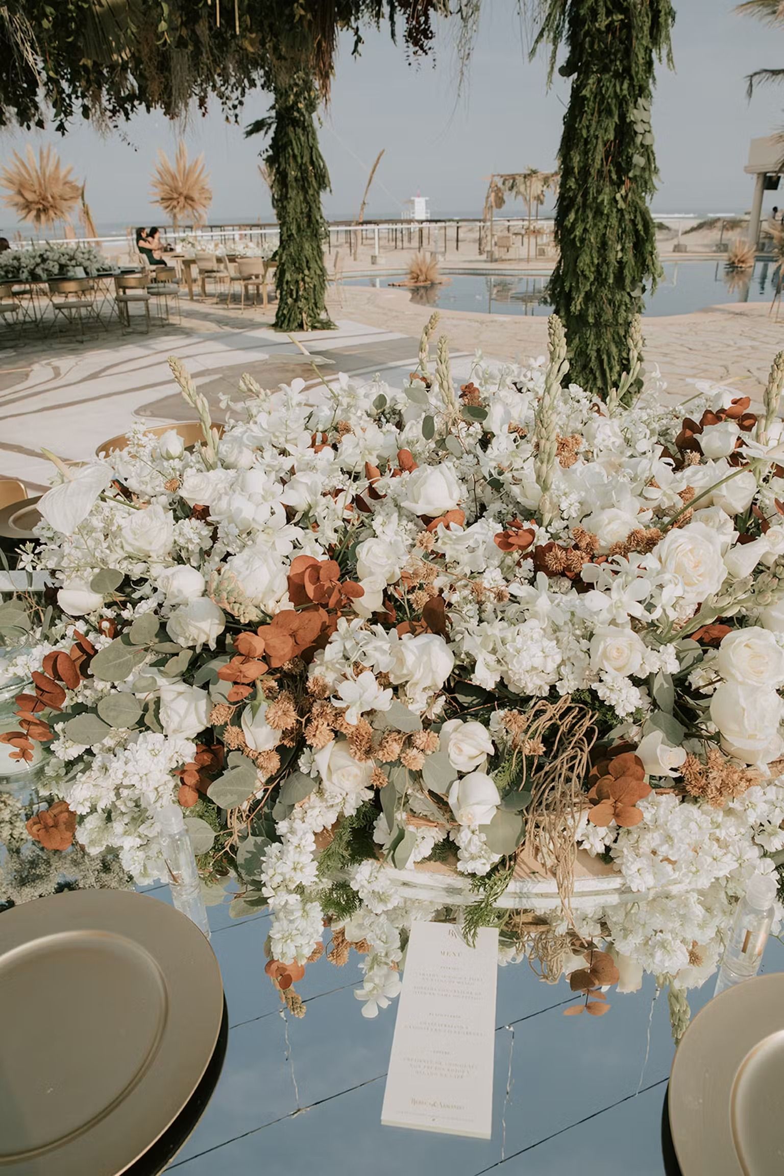 A table with plates and a vase of flowers on it.