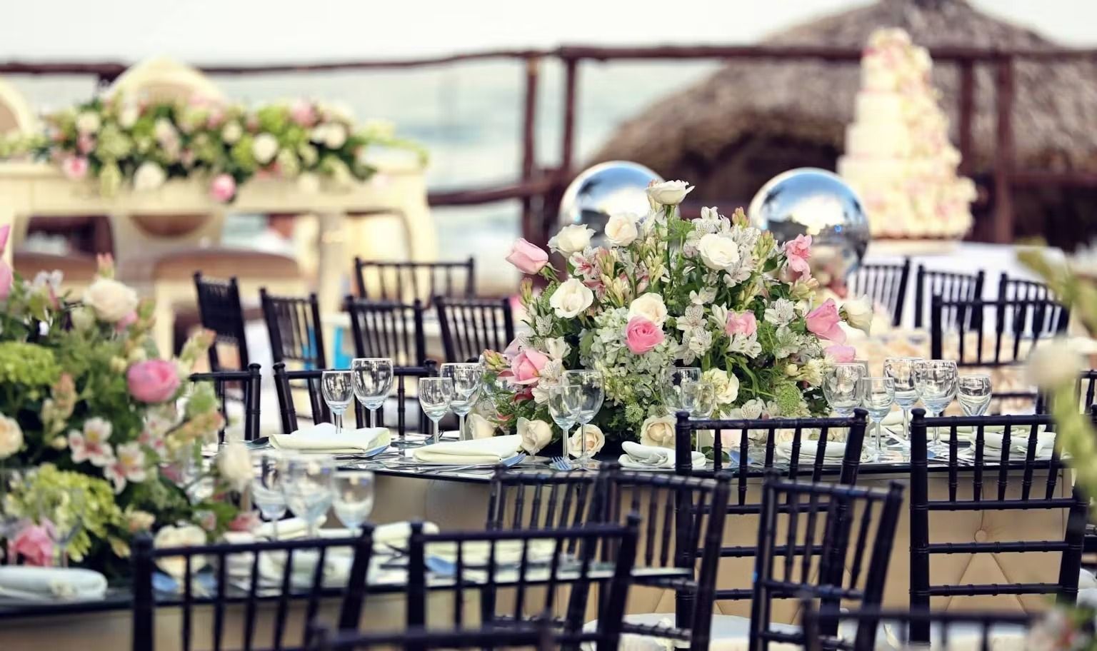 A table set for a wedding reception with flowers and balloons on it.