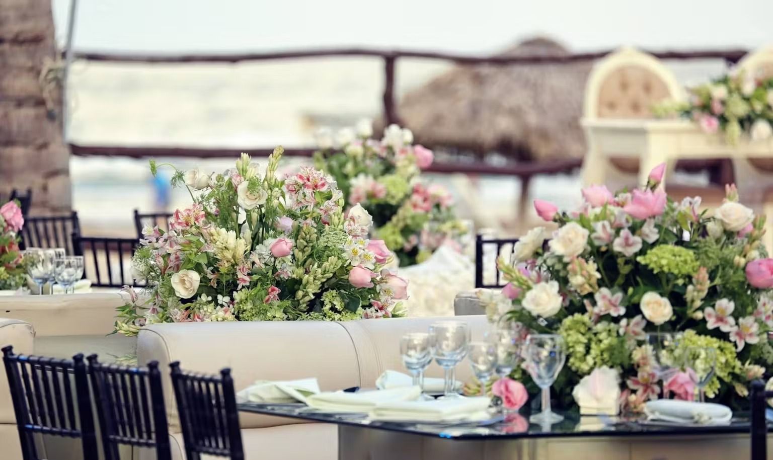 A table set for a wedding reception with flowers on it.