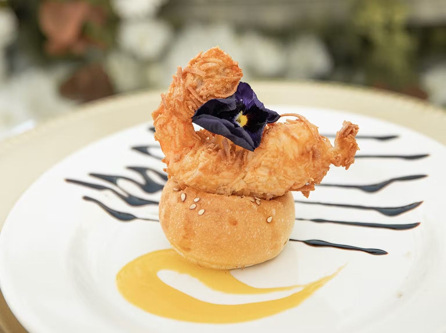 A close up of a plate of food with a flower on top