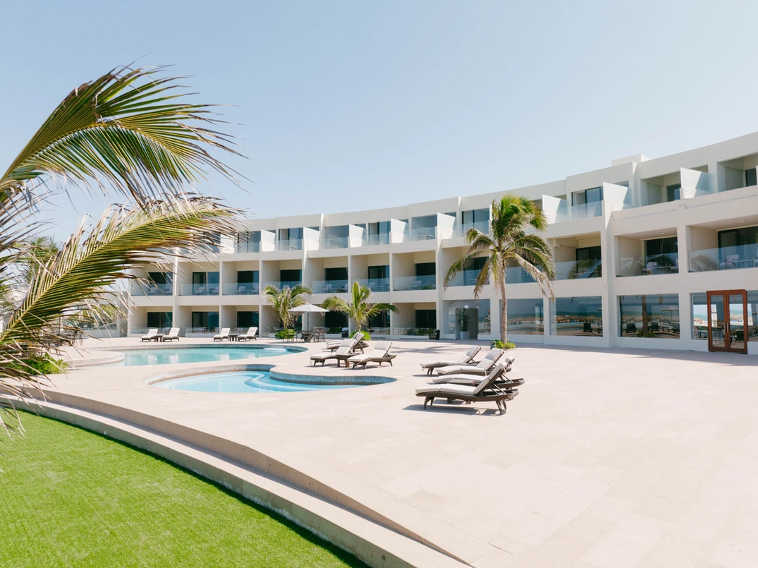 A large white building with a swimming pool in front of it