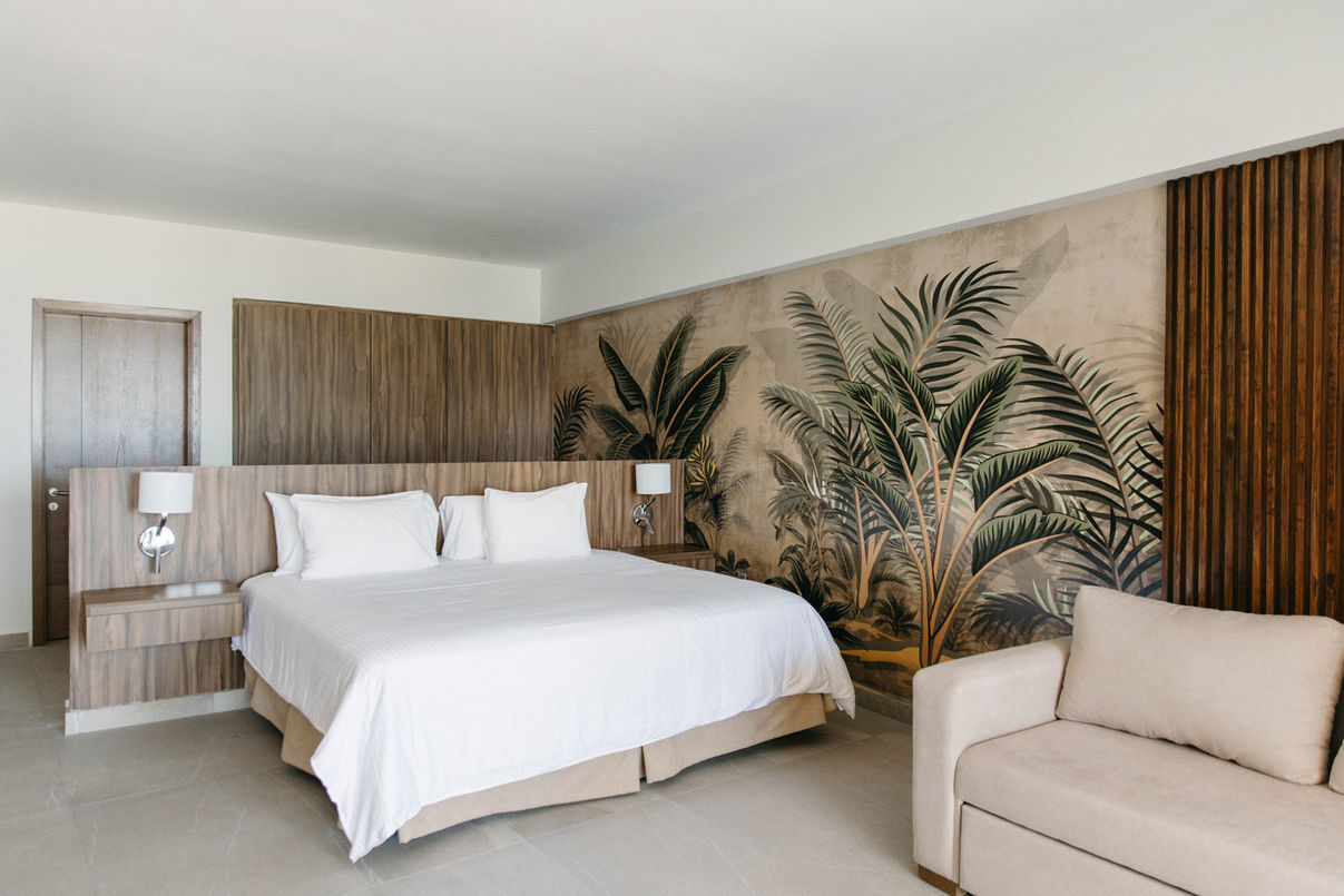 A hotel room with a king size bed and a couch.