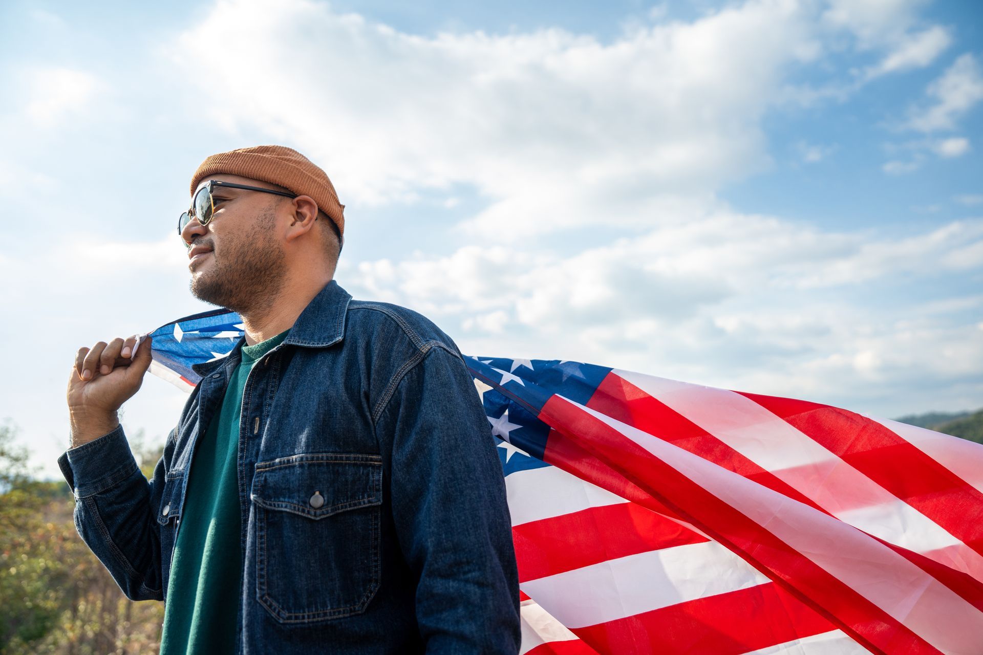 Person holding American flag, looking off,  representing Dreamers (DACA) attorneys in Florida.