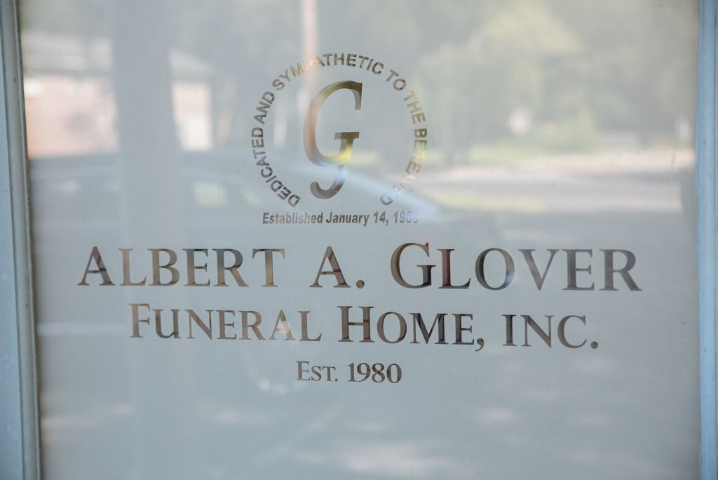 Sign for Albert A. Glover Funeral Home, Inc. on a window. Logo features a stylized 