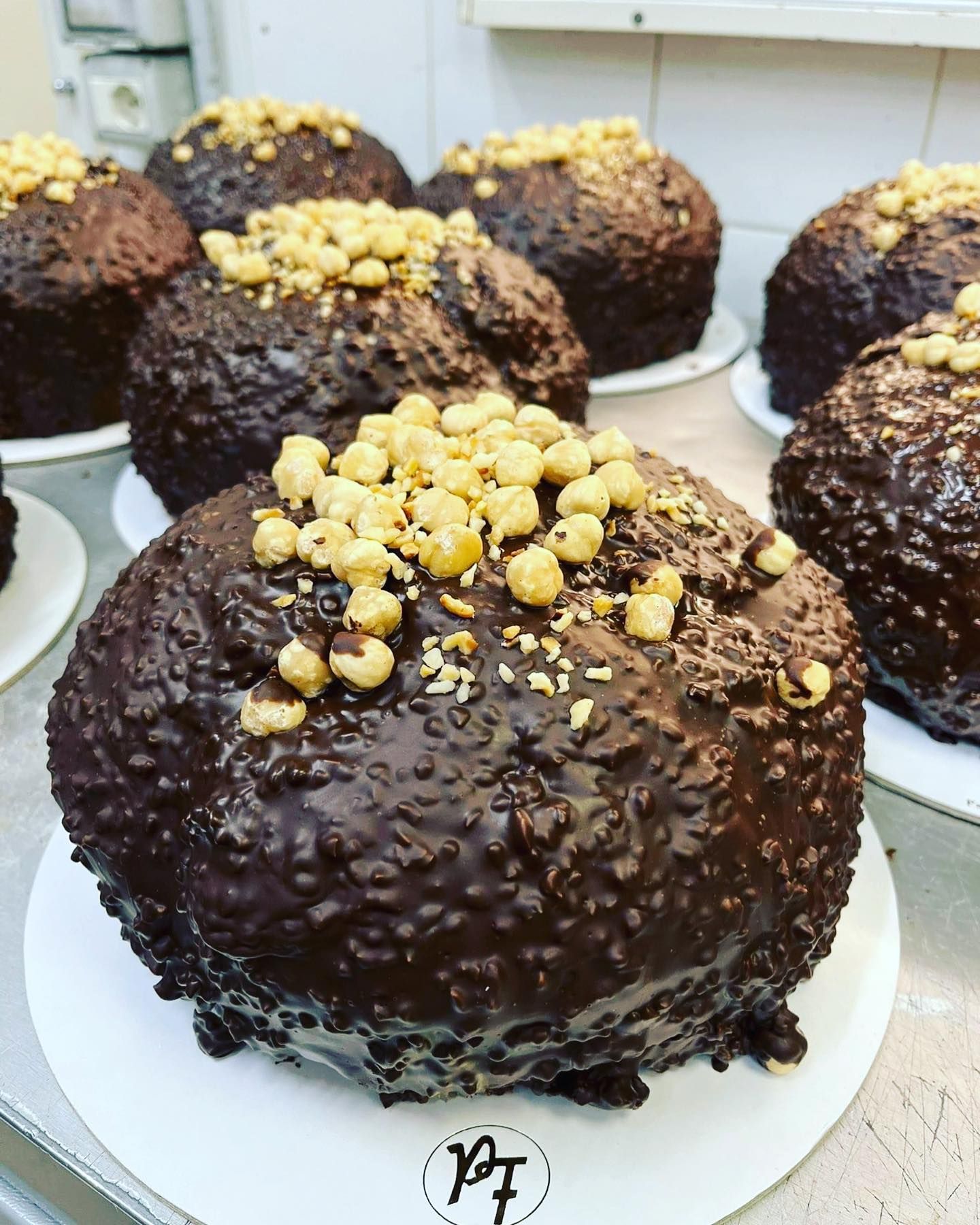 Torte al cioccolato con copertura di nocciole su piatti bianchi.