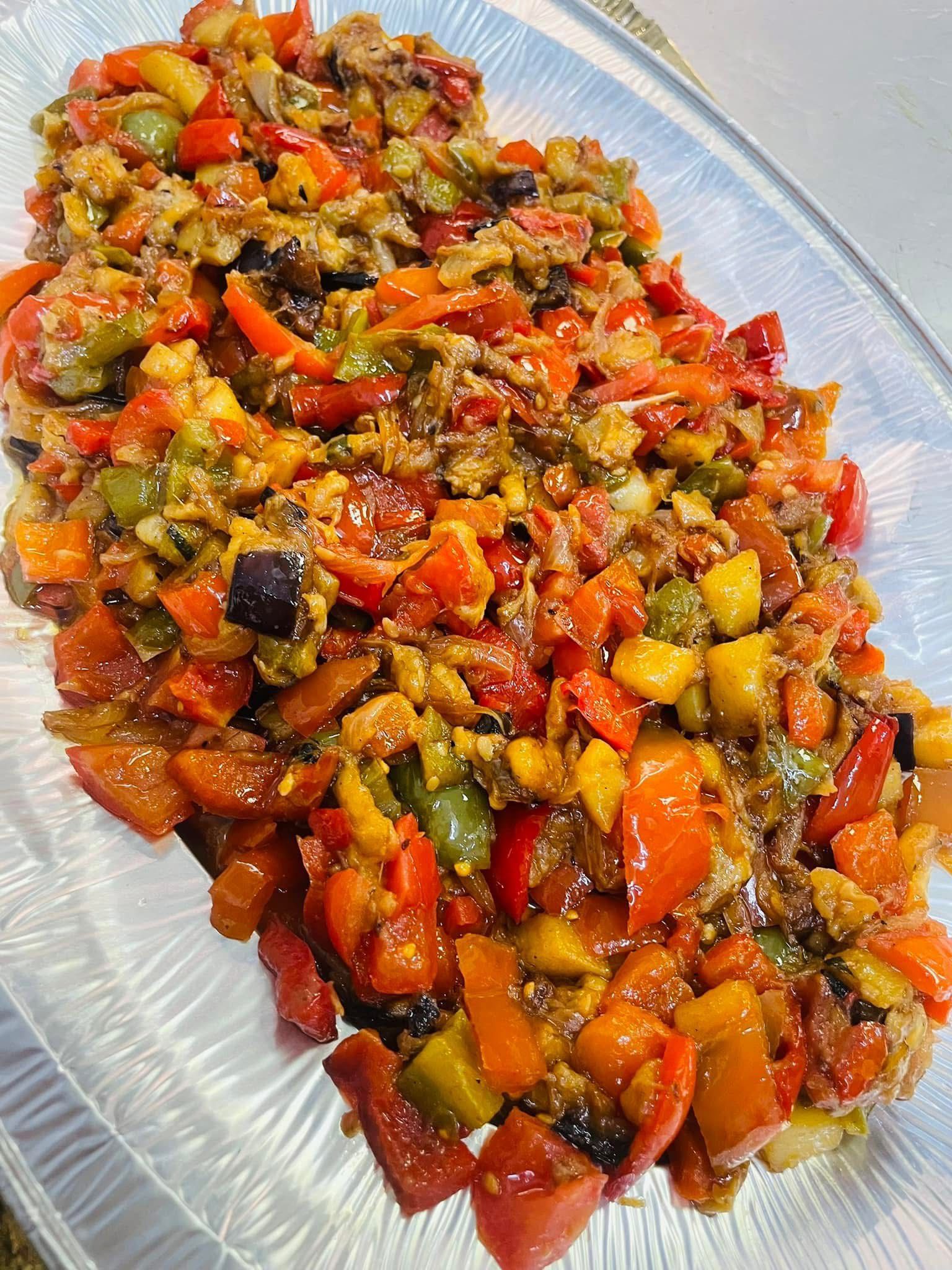 Un colorato mix di verdure su un piatto da portata; spiccano i peperoni rossi, verdi e arancioni.