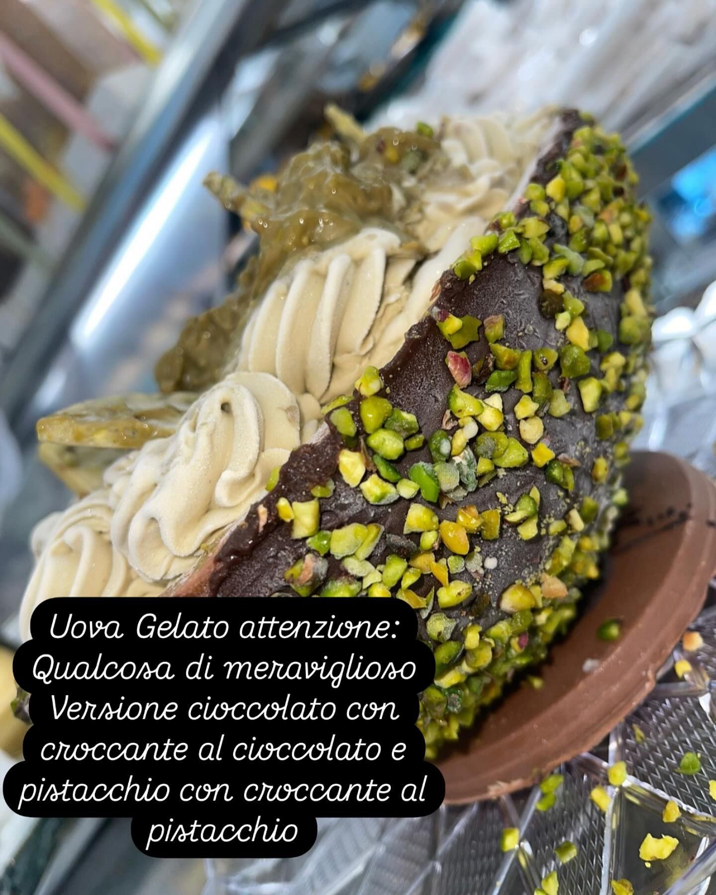 Primo piano di un pasticcino gelato, cioccolato con copertura al pistacchio, ripieno di crema e descrizione testuale.