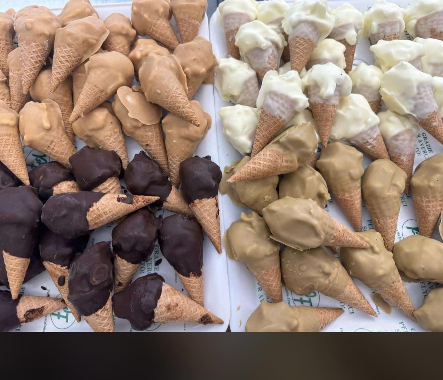 Coni gelato, vari gusti, con coperture marroni, bianche e al cioccolato.