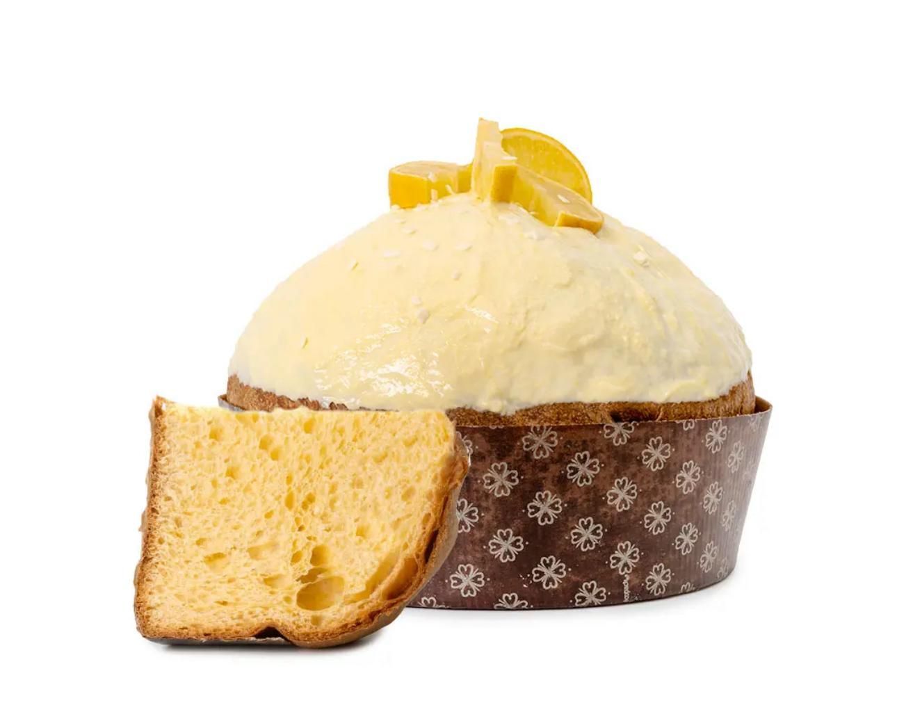 Panettone al limone con una fetta, appoggiato su uno sfondo bianco.