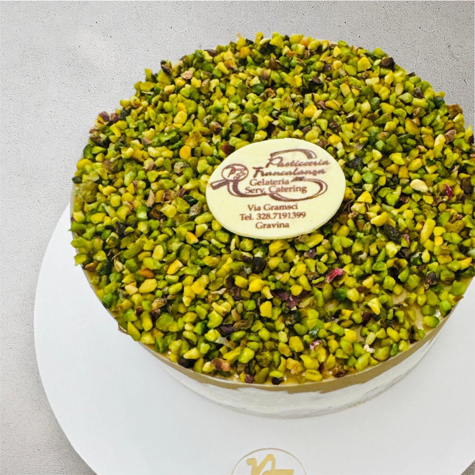 Torta al pistacchio con etichetta bianca sopra, presentata su un piatto bianco.