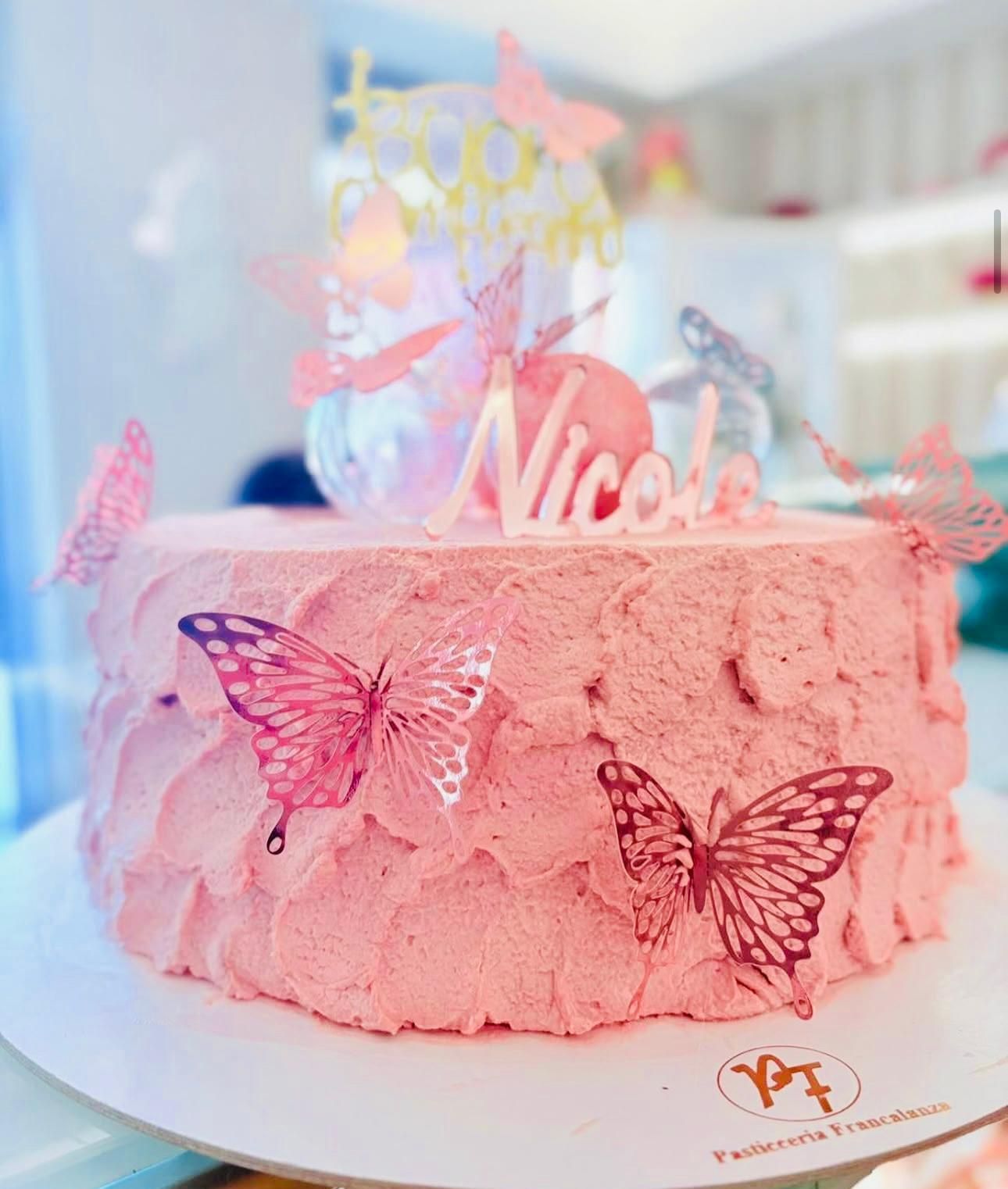 Torta rosa decorata con farfalle e scritta