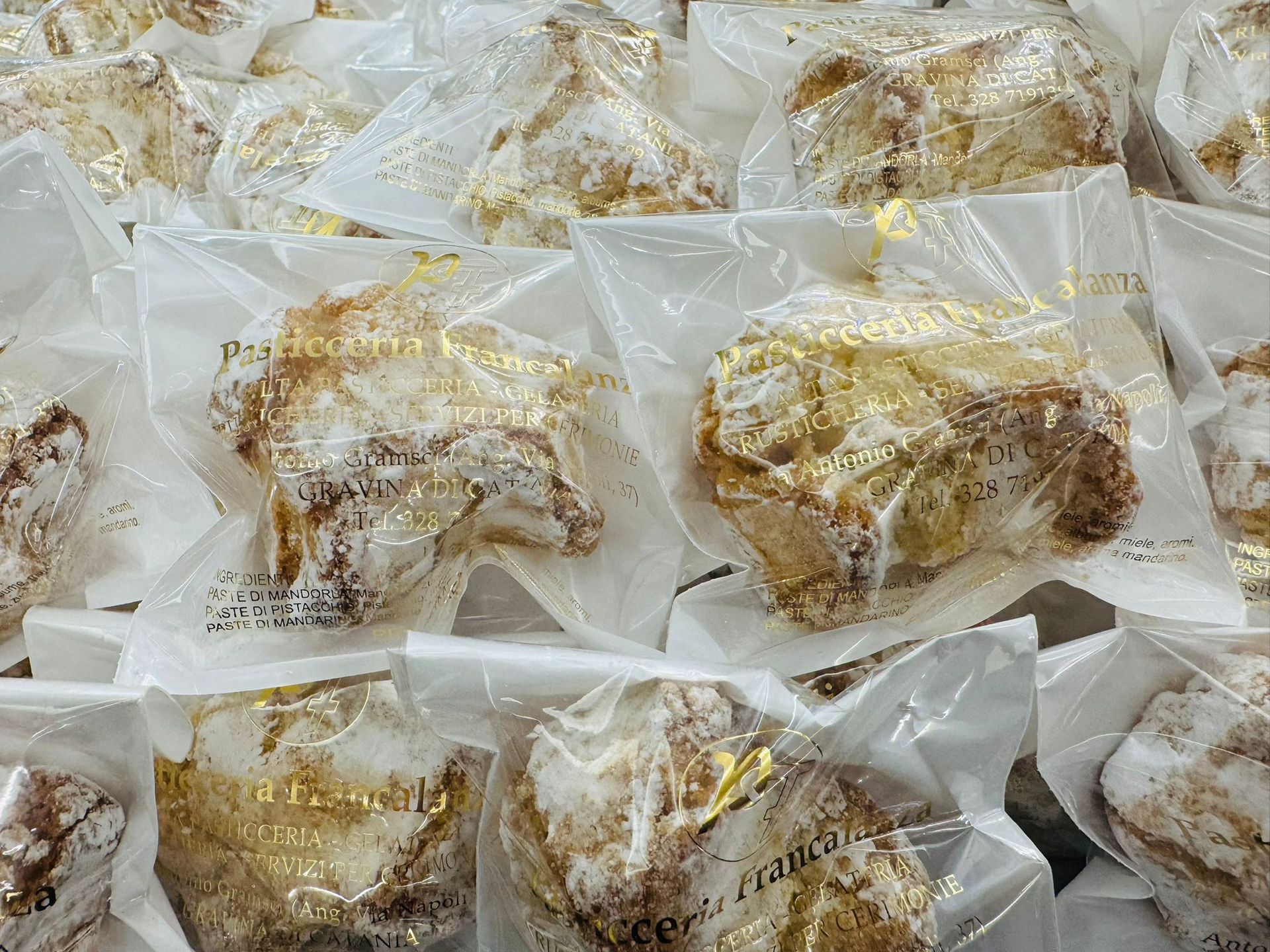 Pasticcini confezionati, spolverati con zucchero a velo, in cellophane trasparente.