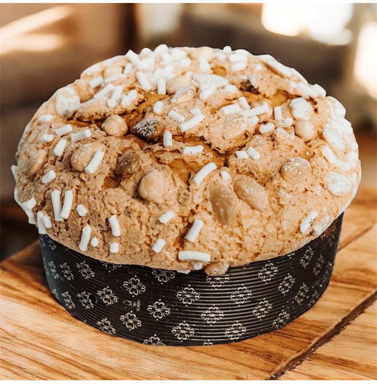 Panettone con glassa al cioccolato e noci su stoffa rossa, decorato per le feste.