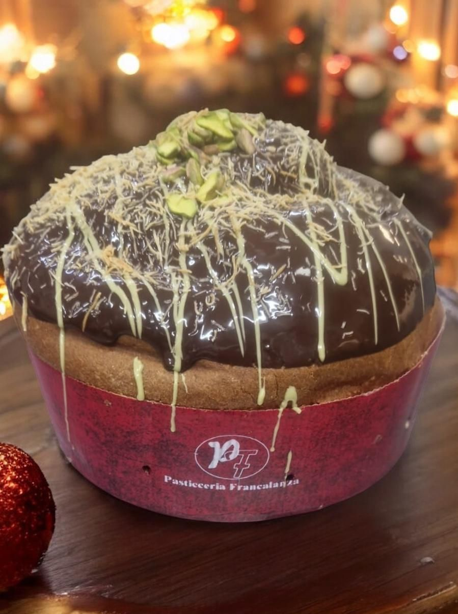 Dessert al cioccolato con glassa, noci e glassa in una tazza rossa, sfondo festivo.