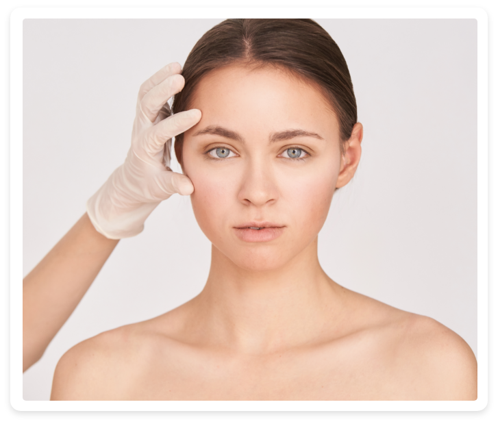 Das Gesicht einer Frau wird von einer Person mit Handschuhen untersucht