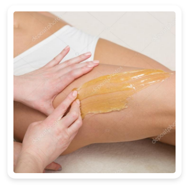 Eine Frau bekommt eine Wachsbehandlung am Bein.