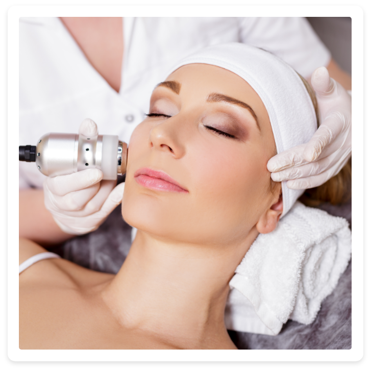 Eine Frau bekommt mit geschlossenen Augen eine Gesichtsbehandlung