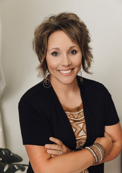A woman is standing with her arms crossed.