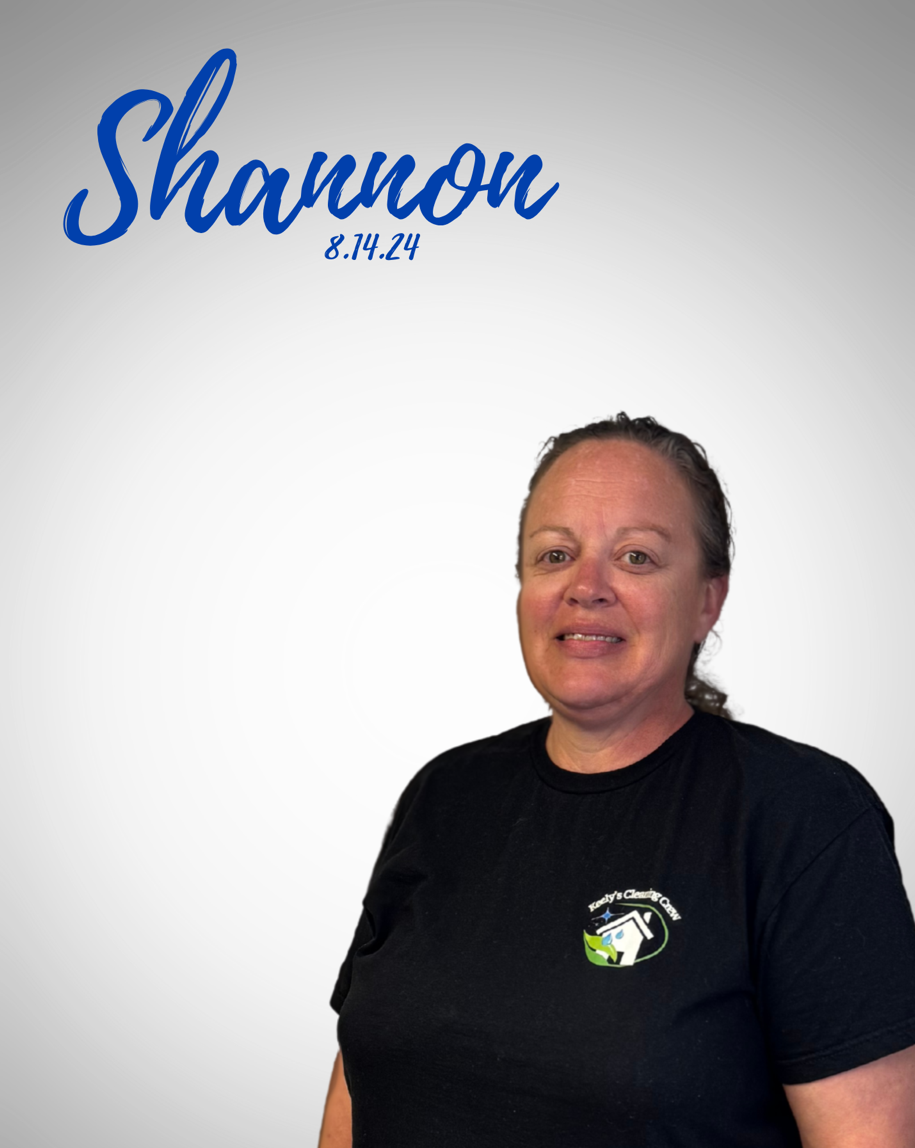 A woman in a black shirt and blue jeans is standing with her hands on her hips.