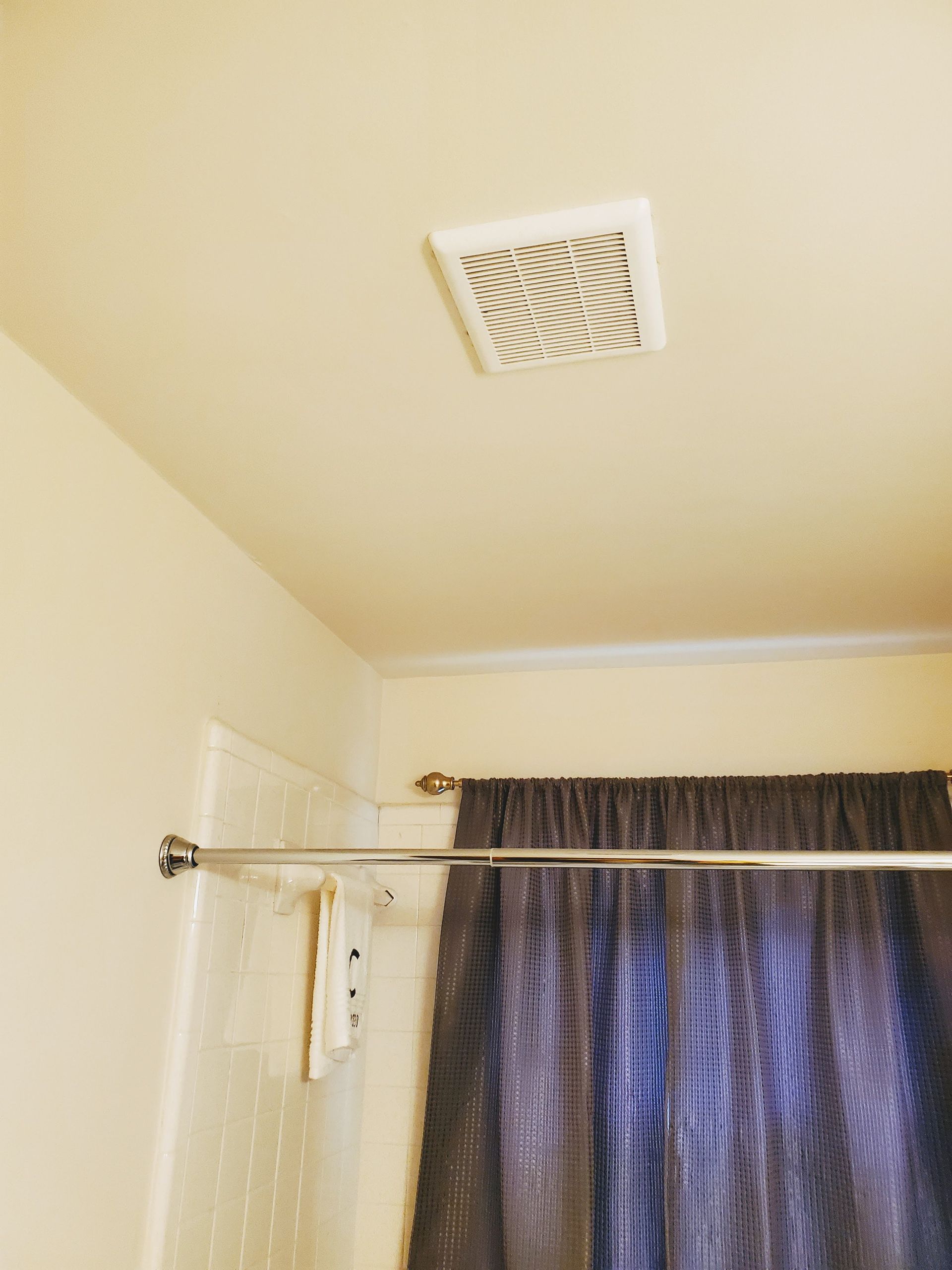 a bathroom with a shower curtain and a ceiling fan