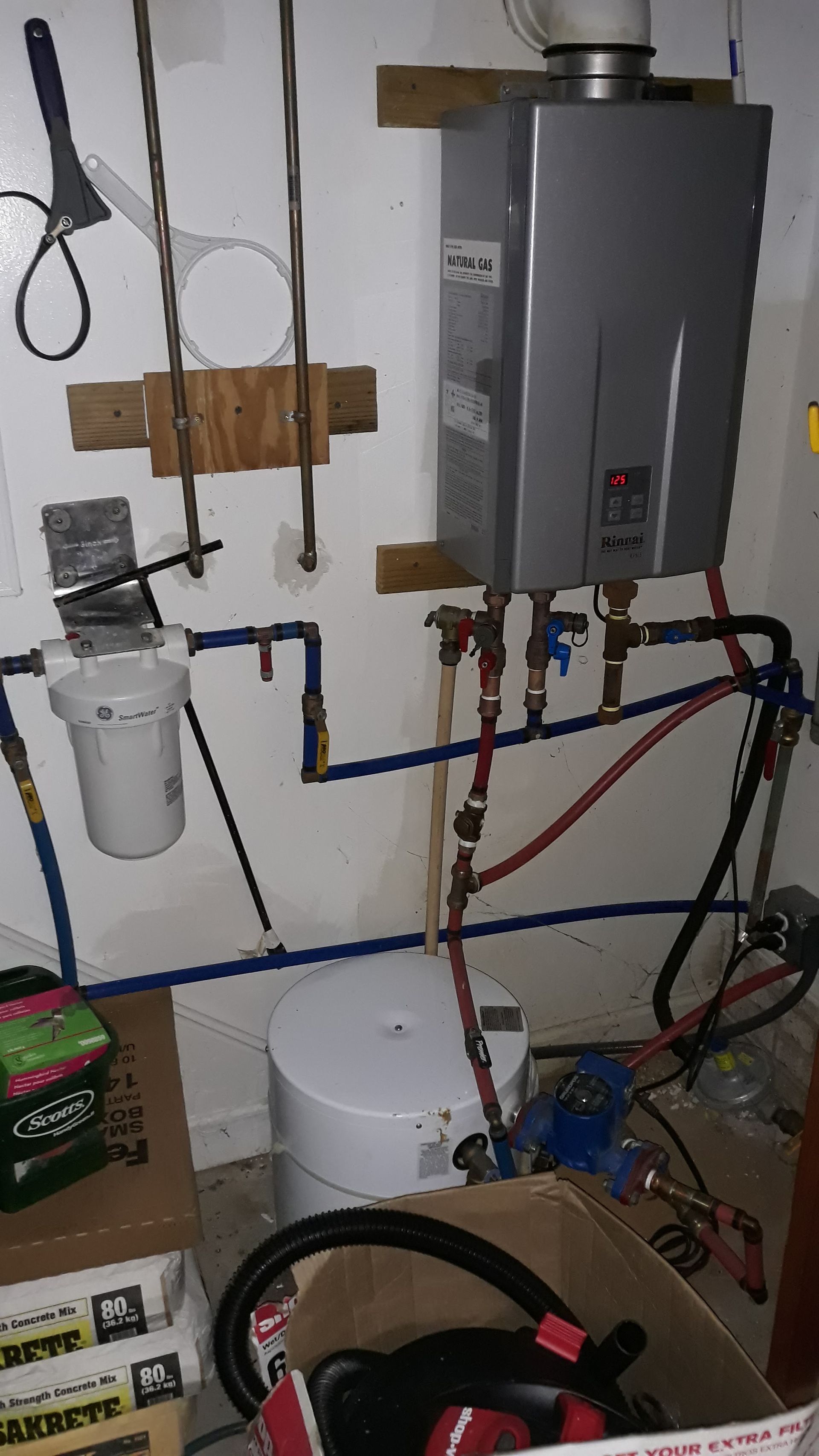 a water heater is sitting next to a water heater in a room