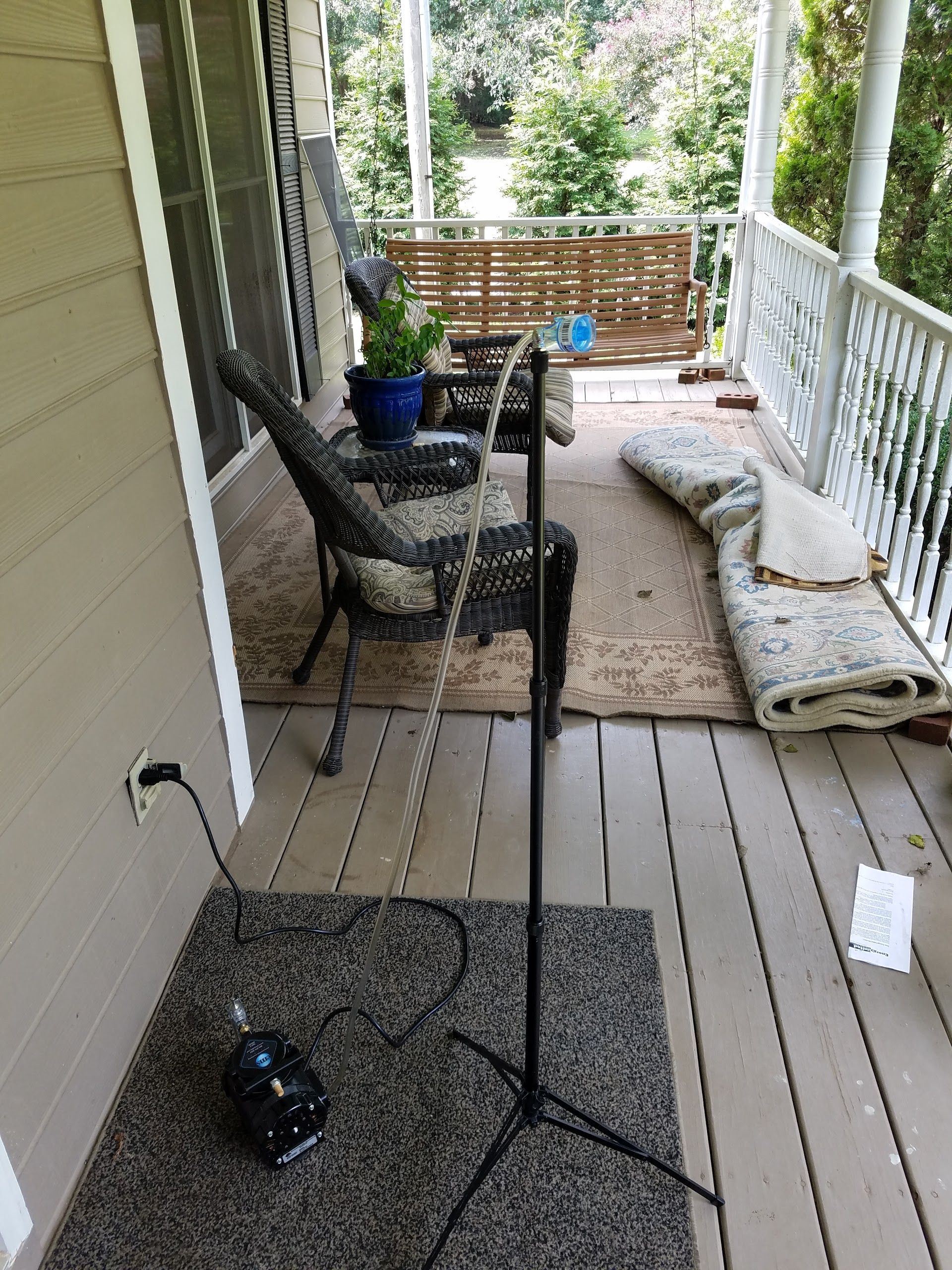 a microphone stand is sitting on a porch next to a chair