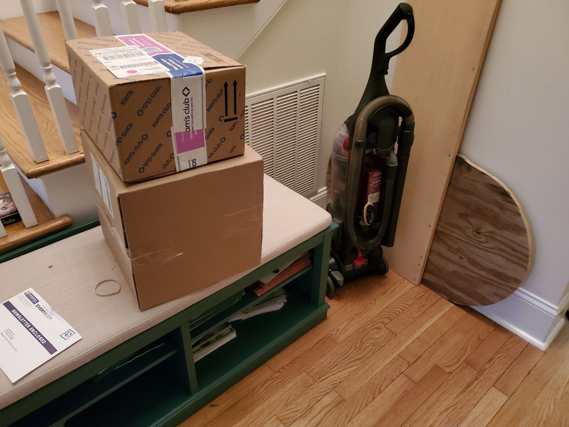 two boxes are stacked on top of each other on a bench next to a vacuum cleaner