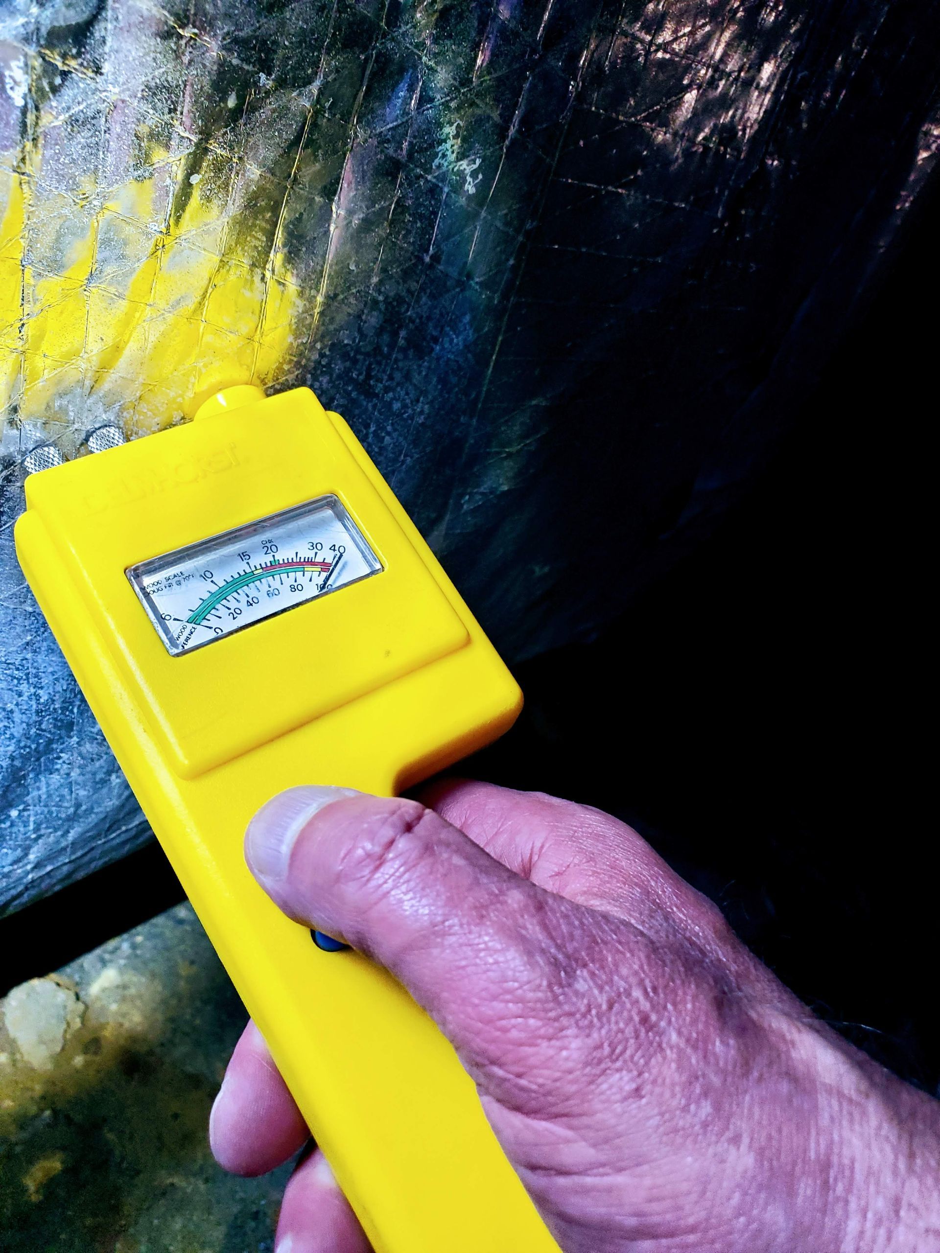 a person is holding a yellow device that says ' moisture meter ' on it