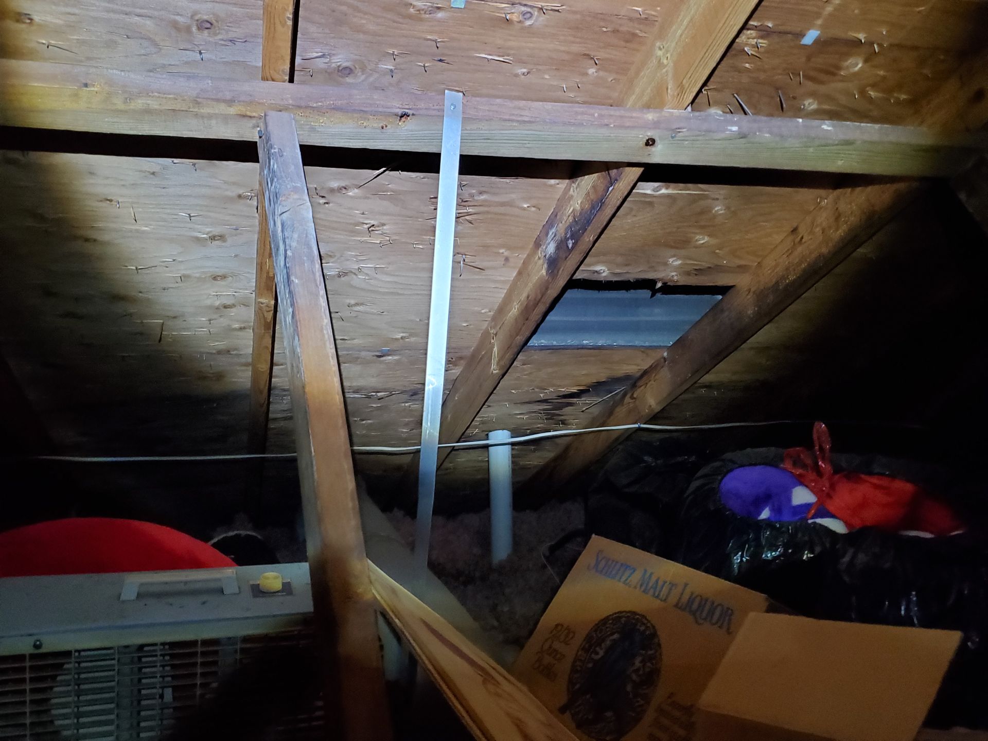 a dark attic with a lot of boxes and a fan