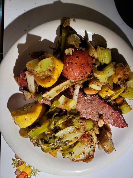 A plate of food with meat and vegetables on a table