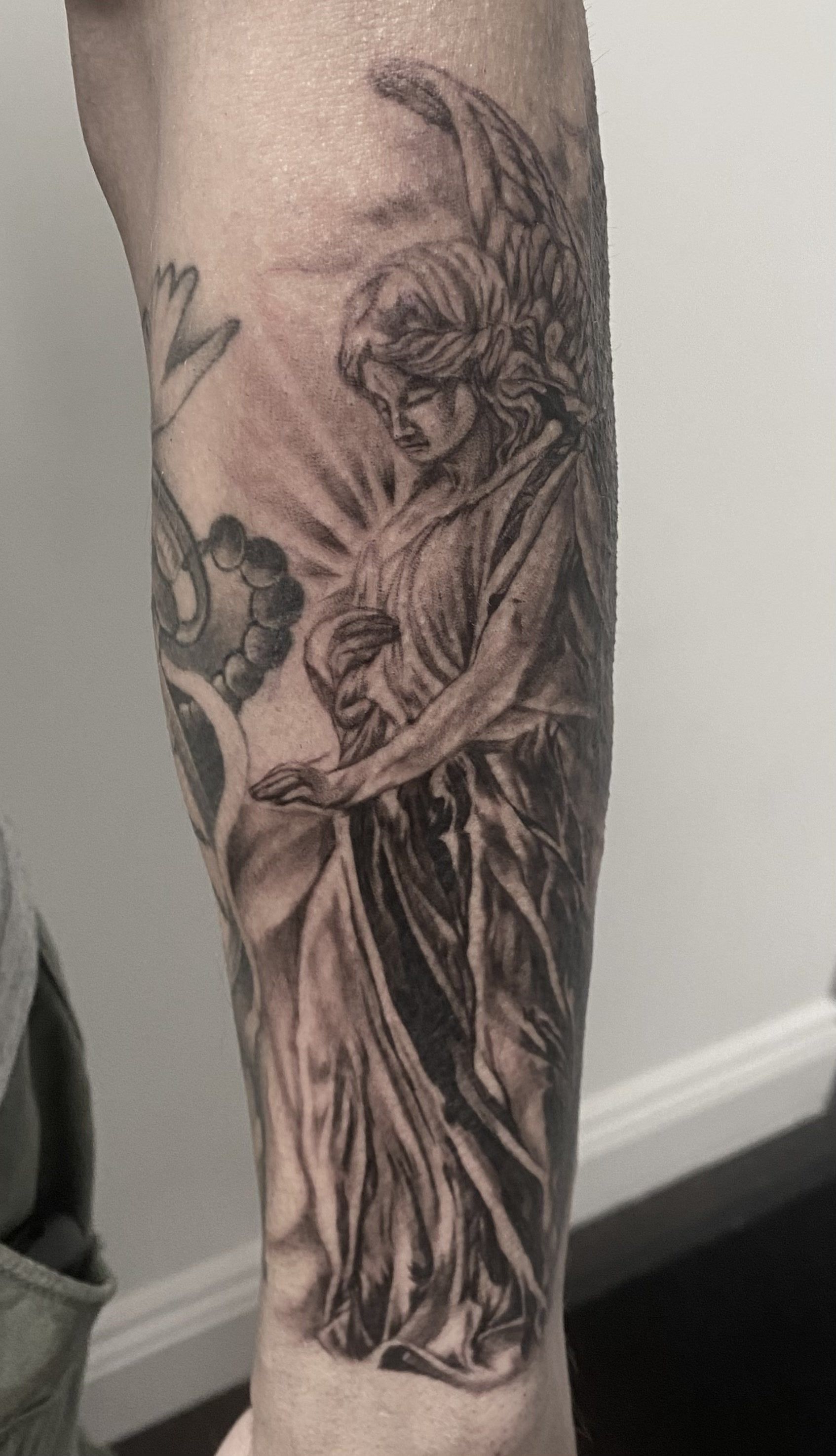 Black and grey realism angel statue tattoo 