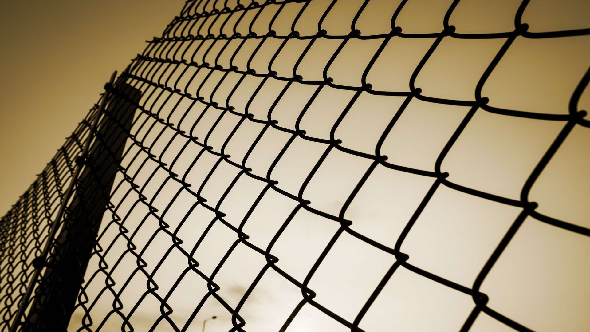 A chain link fence is surrounding a baseball field.