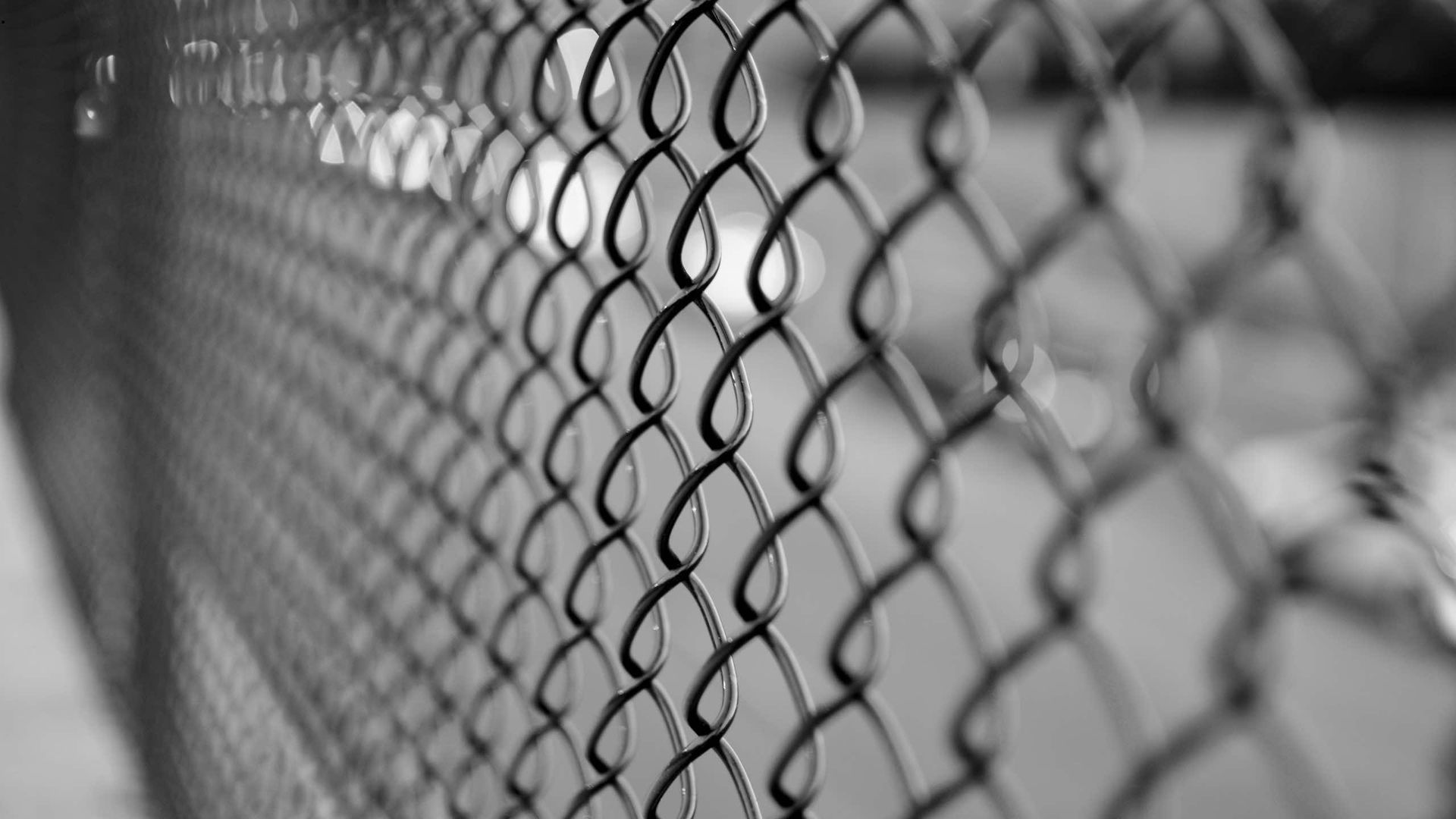 A black and white photo of a chain link fence.