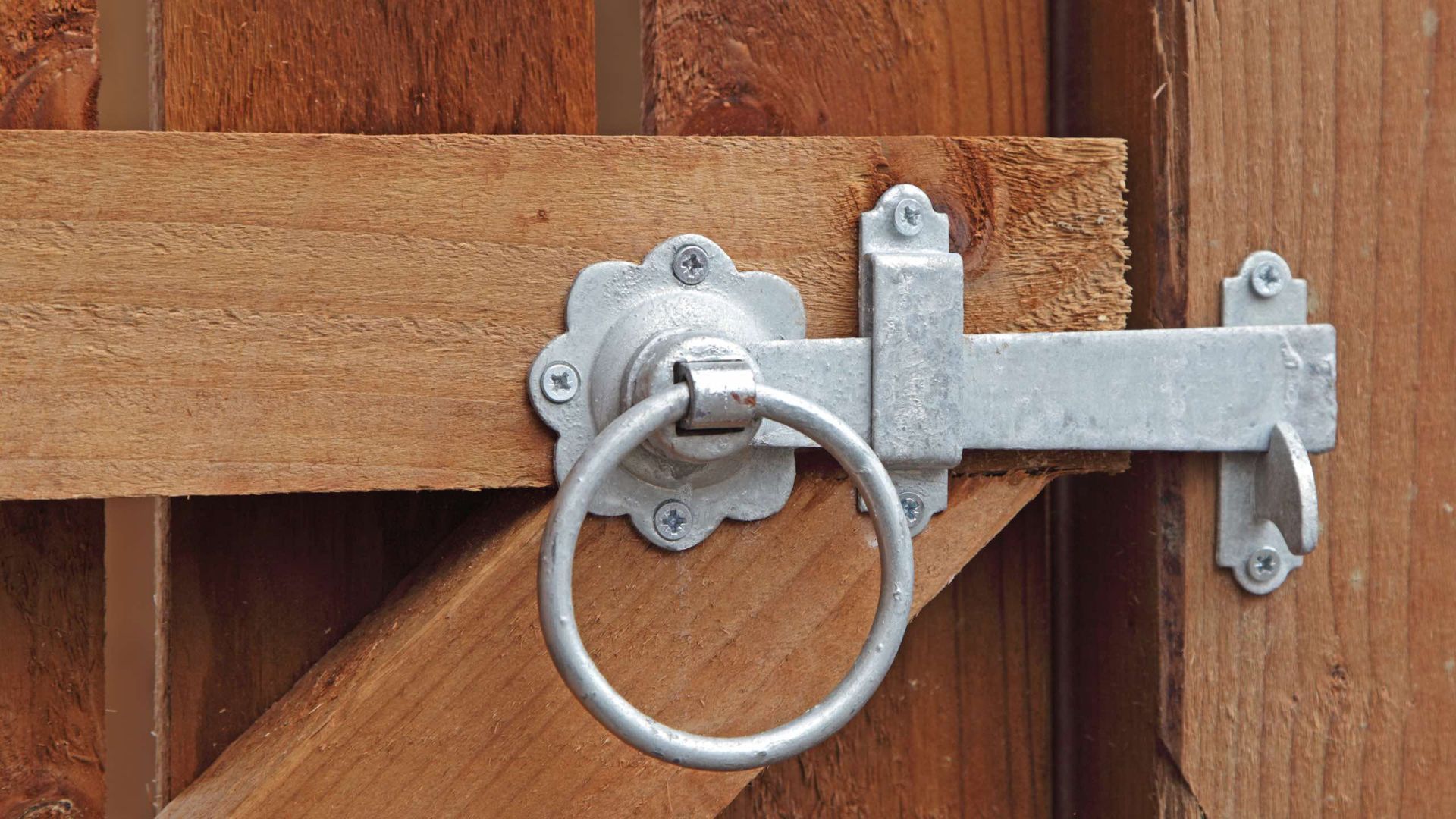 A close up of a latch on a wooden fence