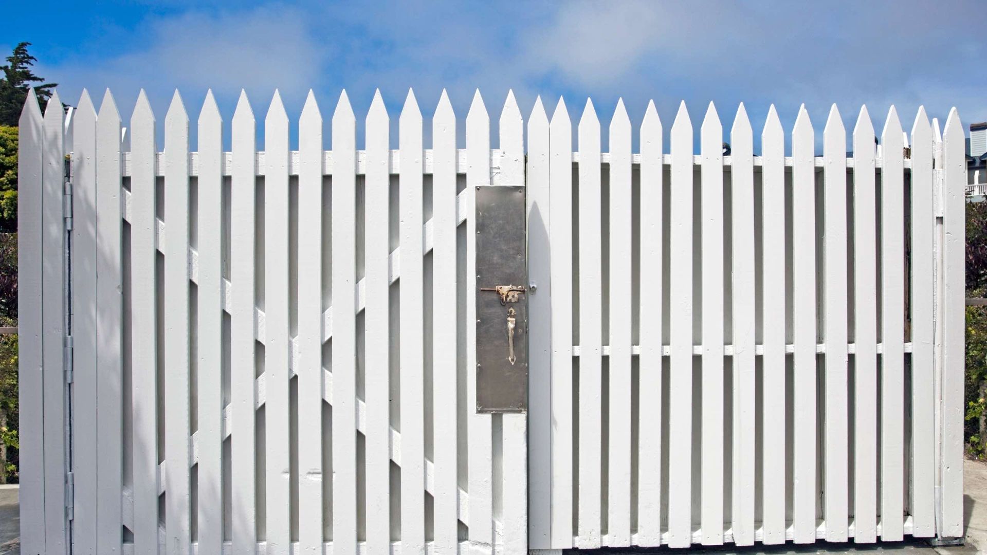 A white picket fence with a mailbox in the middle of it.