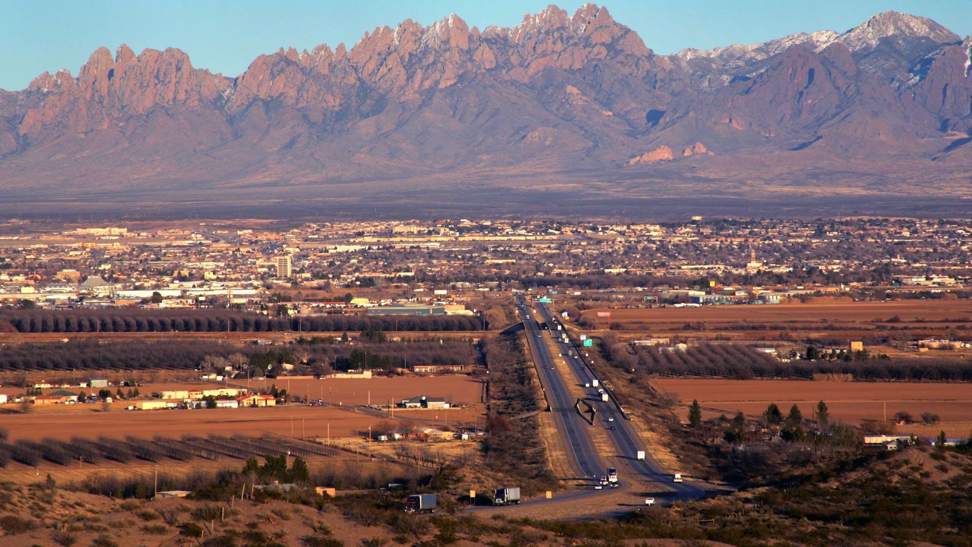 A city in the desert with mountains in the background