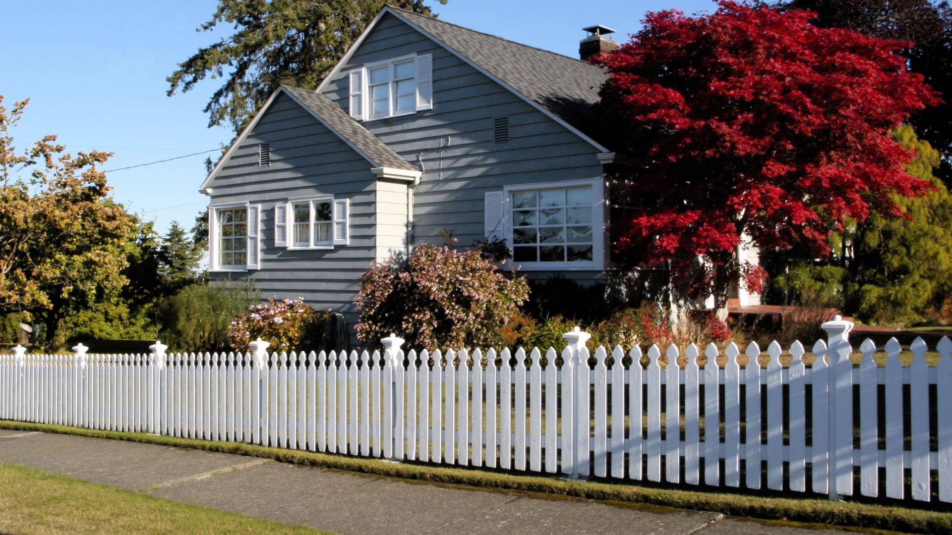 A house with a white picket fence in front of it