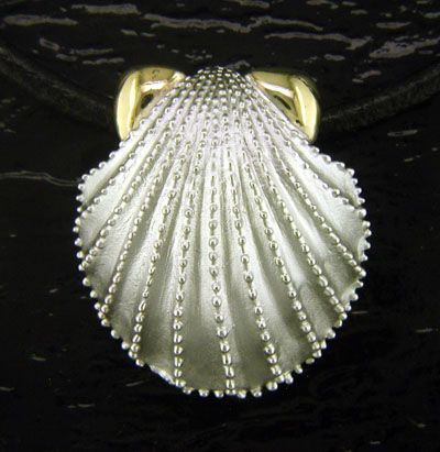 A silver seashell shaped ring with a gold band