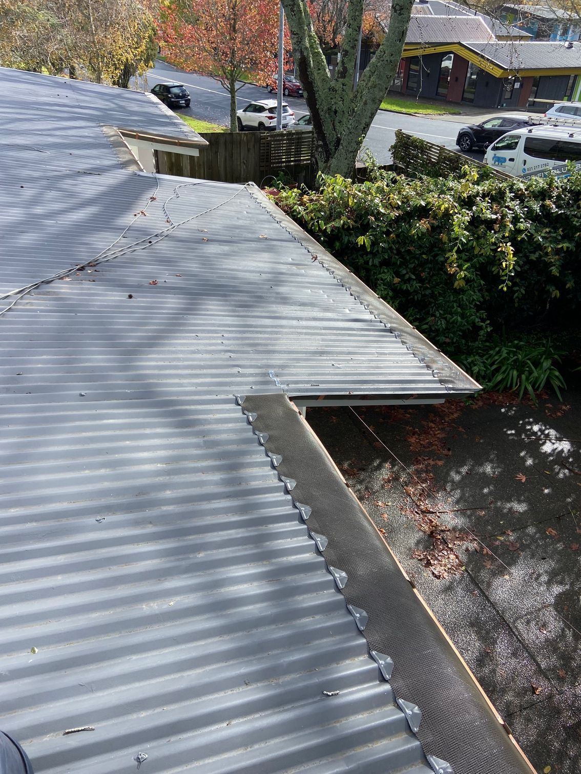 Grey corrugated metal roof with gutter guard, angled view.