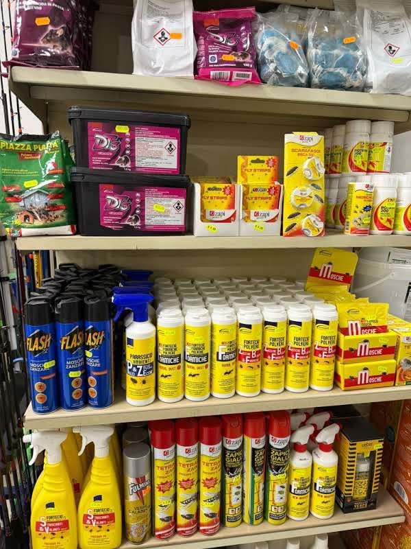 Scaffali di un negozio pieni di vari prodotti per la pulizia, tra cui flaconi spray, contenitori e bombolette aerosol.