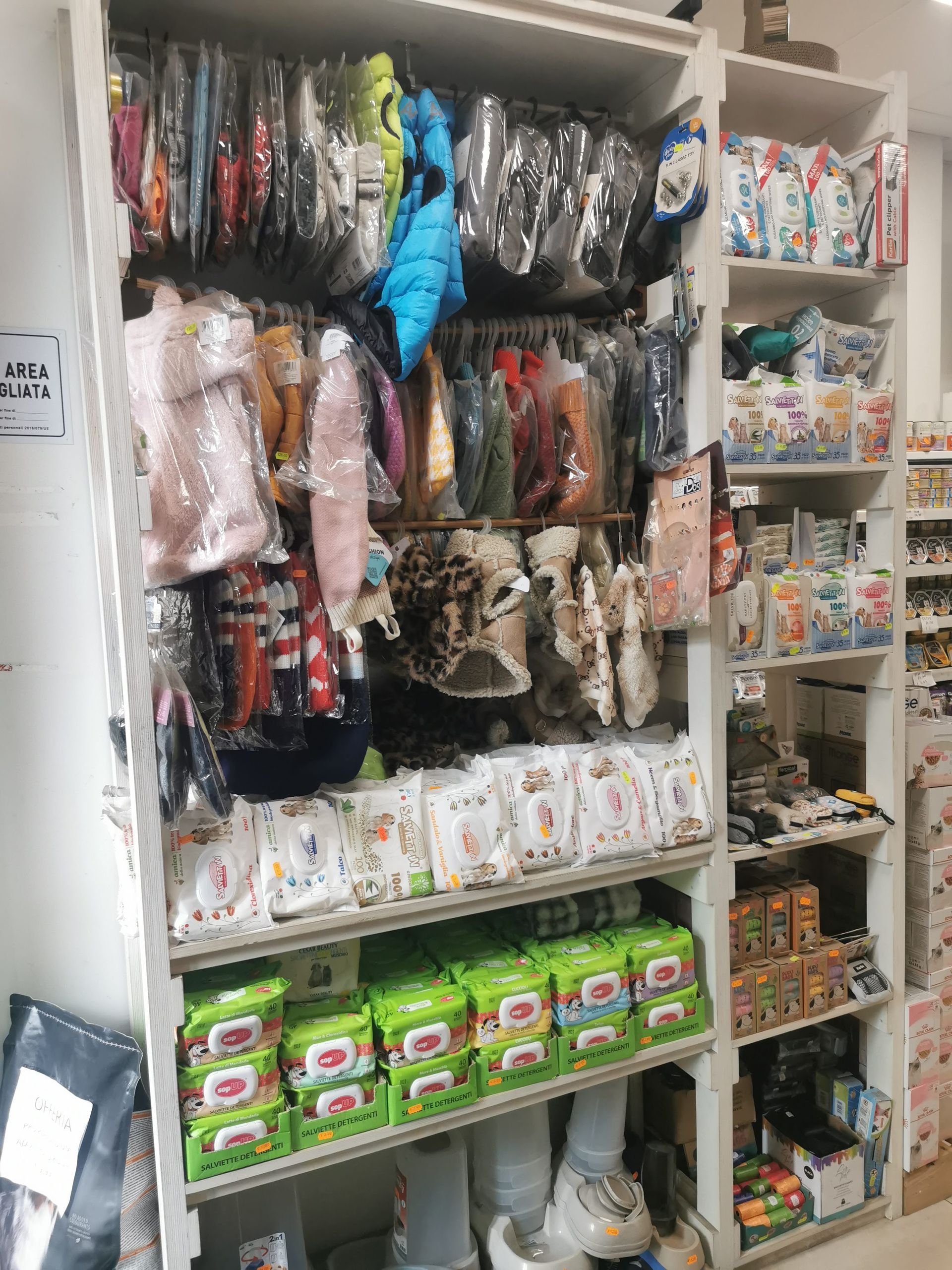 Scaffali di un negozio al dettaglio pieni di abbigliamento per bambini, pannolini e vari prodotti per la cura dei neonati.
