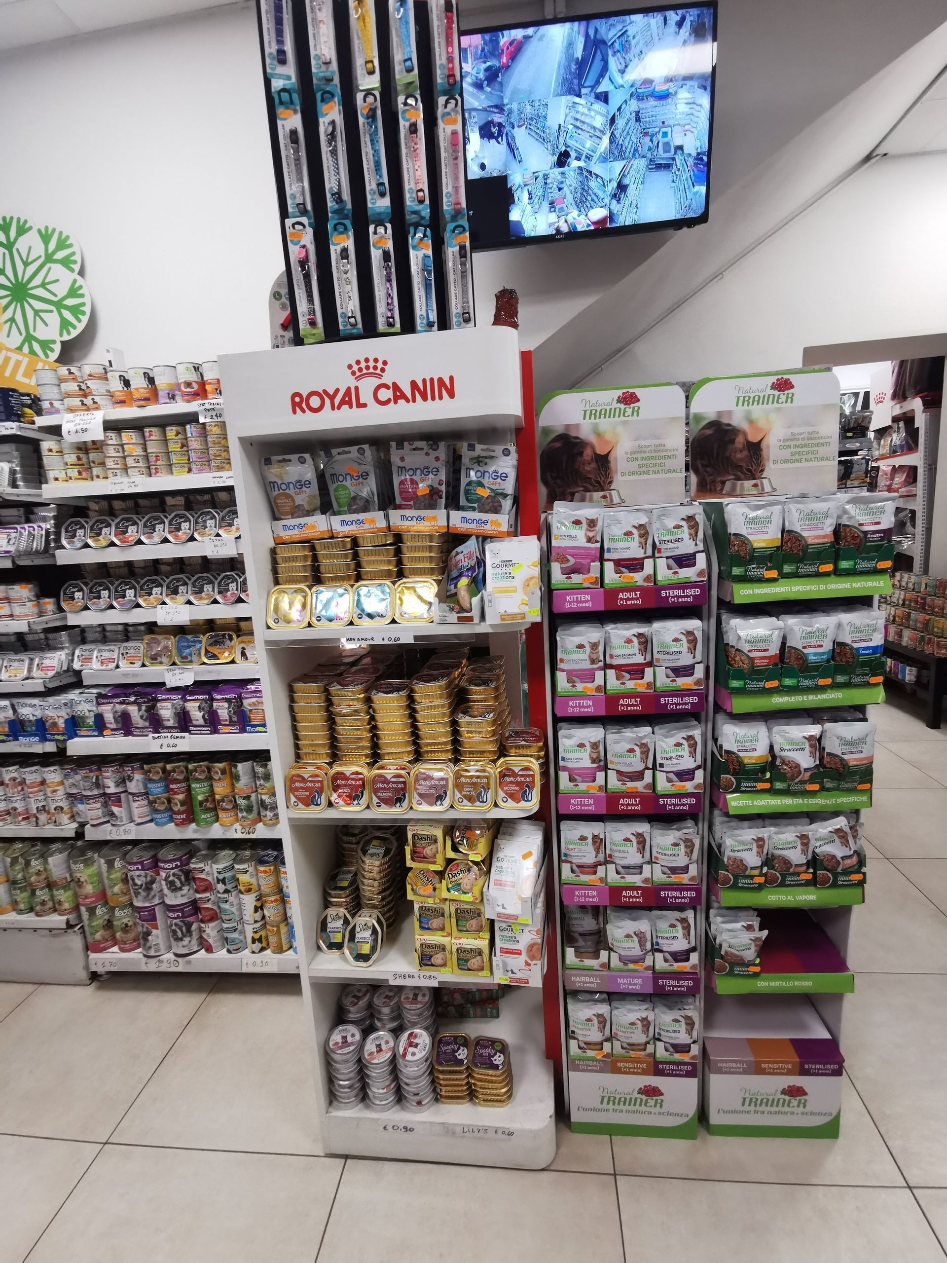 All'interno di un negozio, degli espositori pieni di prodotti Royal Canin e di altri alimenti per animali domestici.