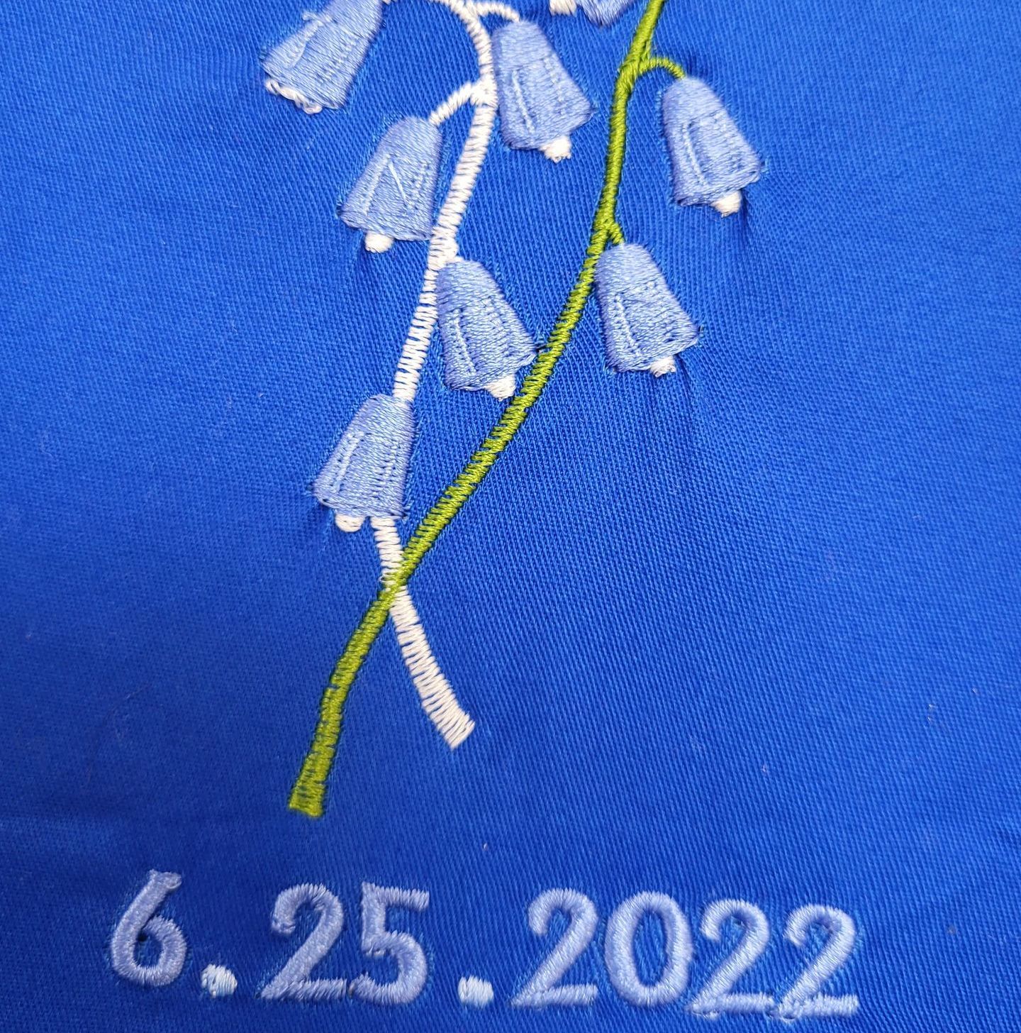 Blue embroidered flower and date,