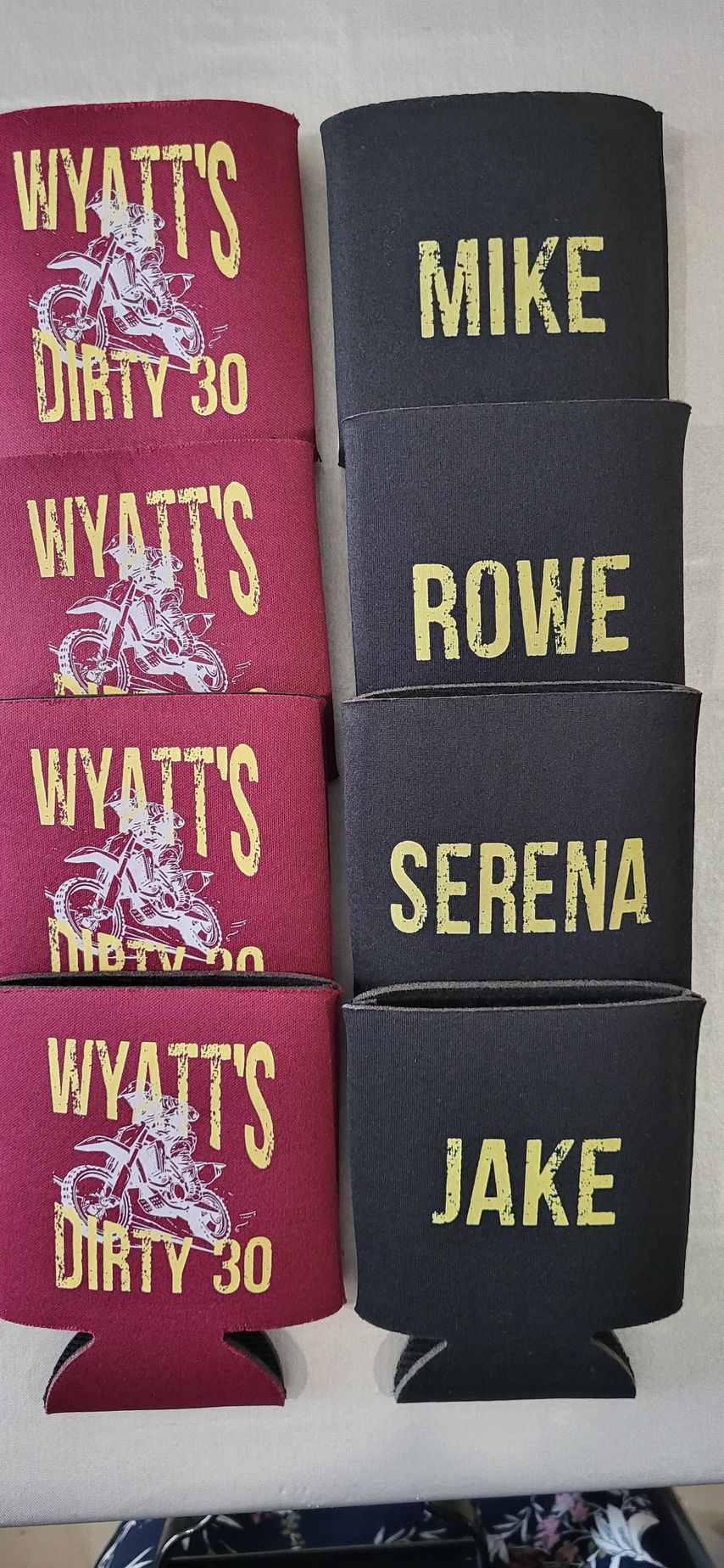 Red and black koozies. Red koozies say